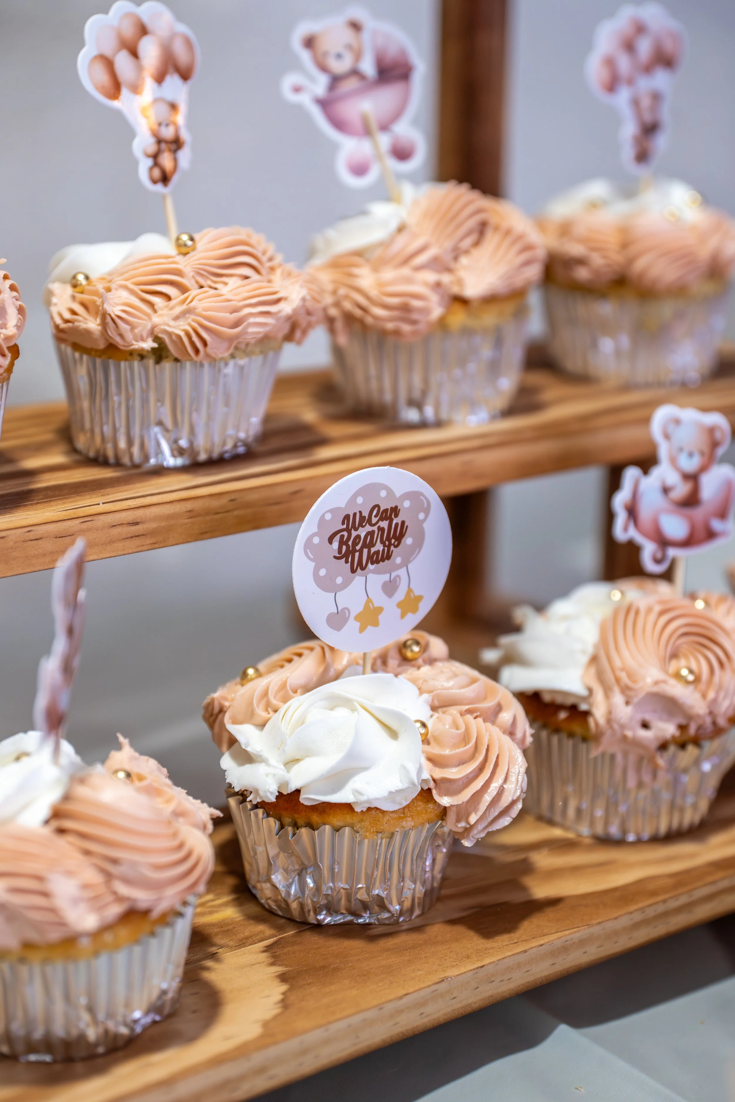 Couple walking on the beach, woman holding a sign announcing pregnancy, text reading "Baby Dozzo Coming Soon December 2024."