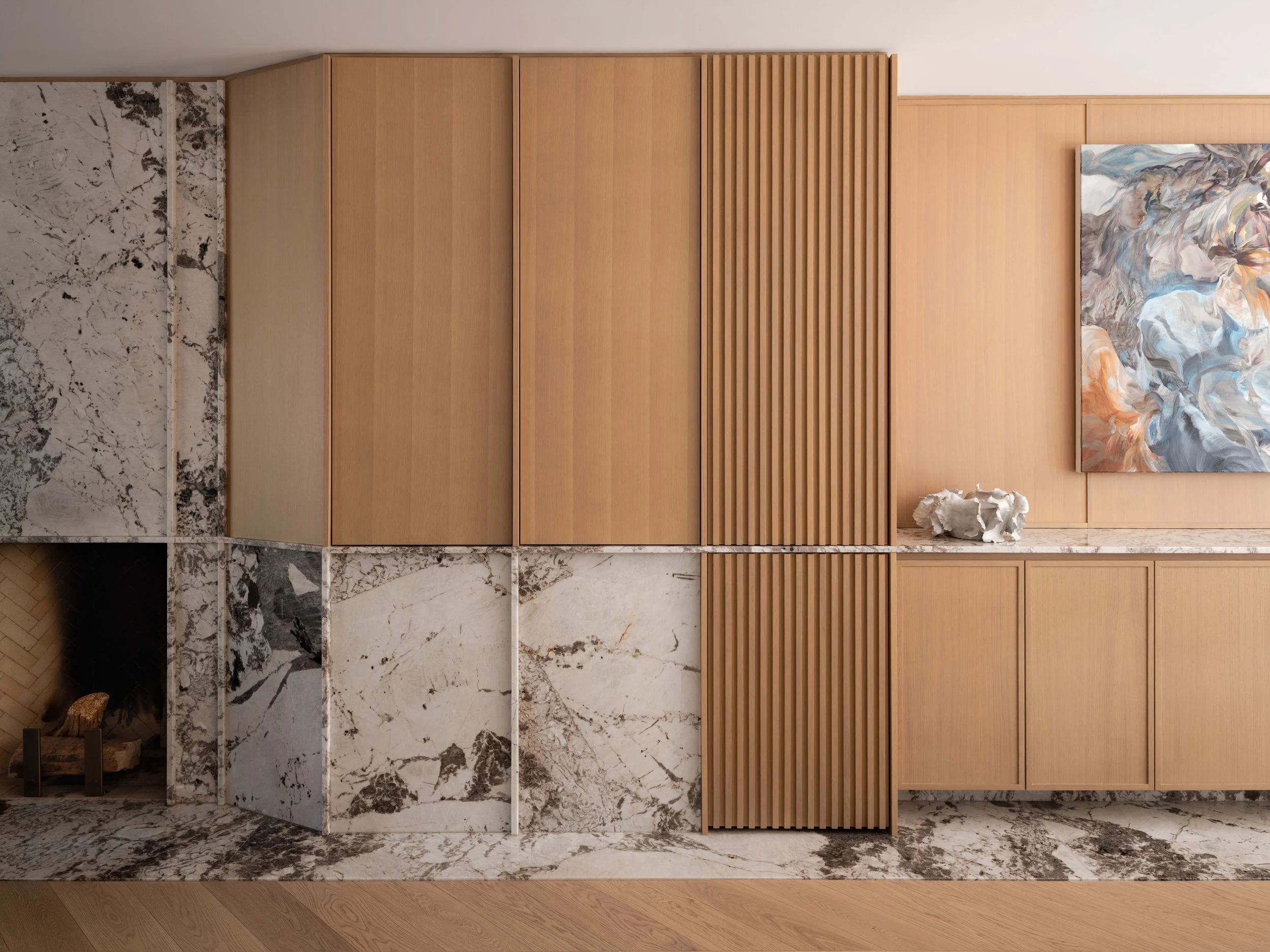 Interior millwork wall with wooden panels, marble accents, and artwork displayed.