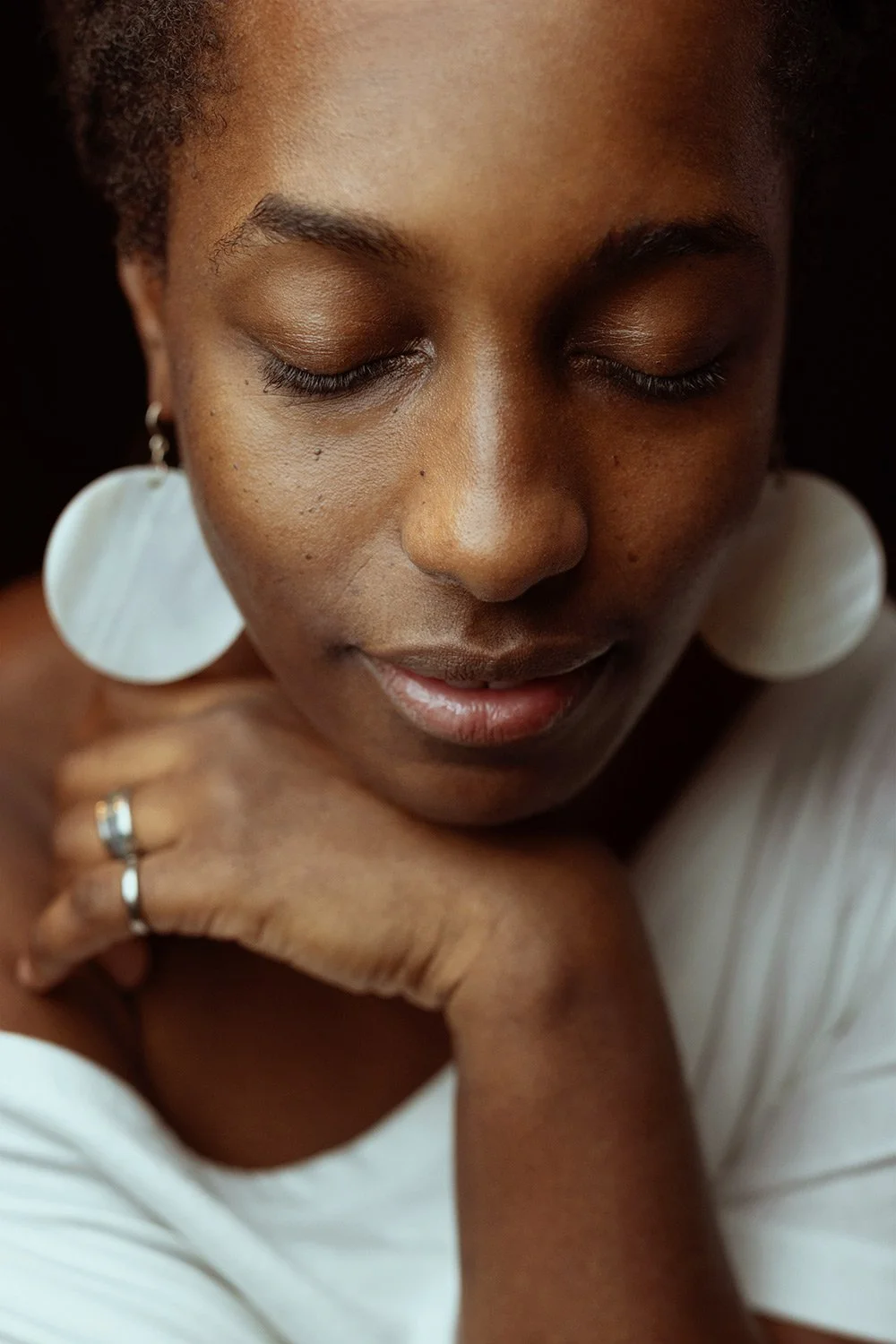 intimate-vulnerable-portrait-woman-white-earrings-studio-closeup-copenhagen.jpg
