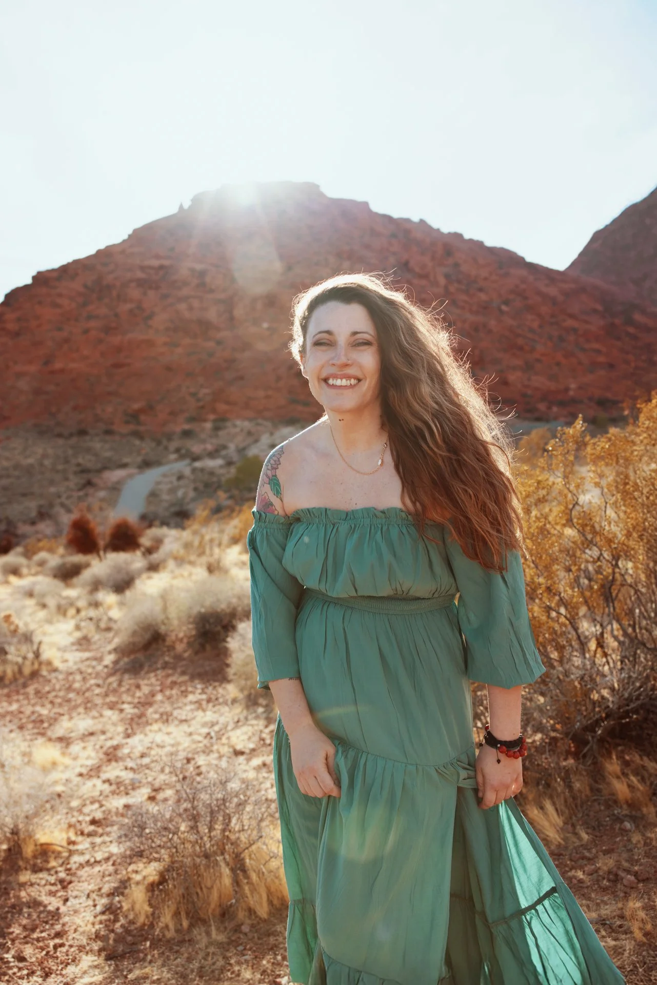 desert-portrait-smiling-woman-green-dress-sun-flare.jpg