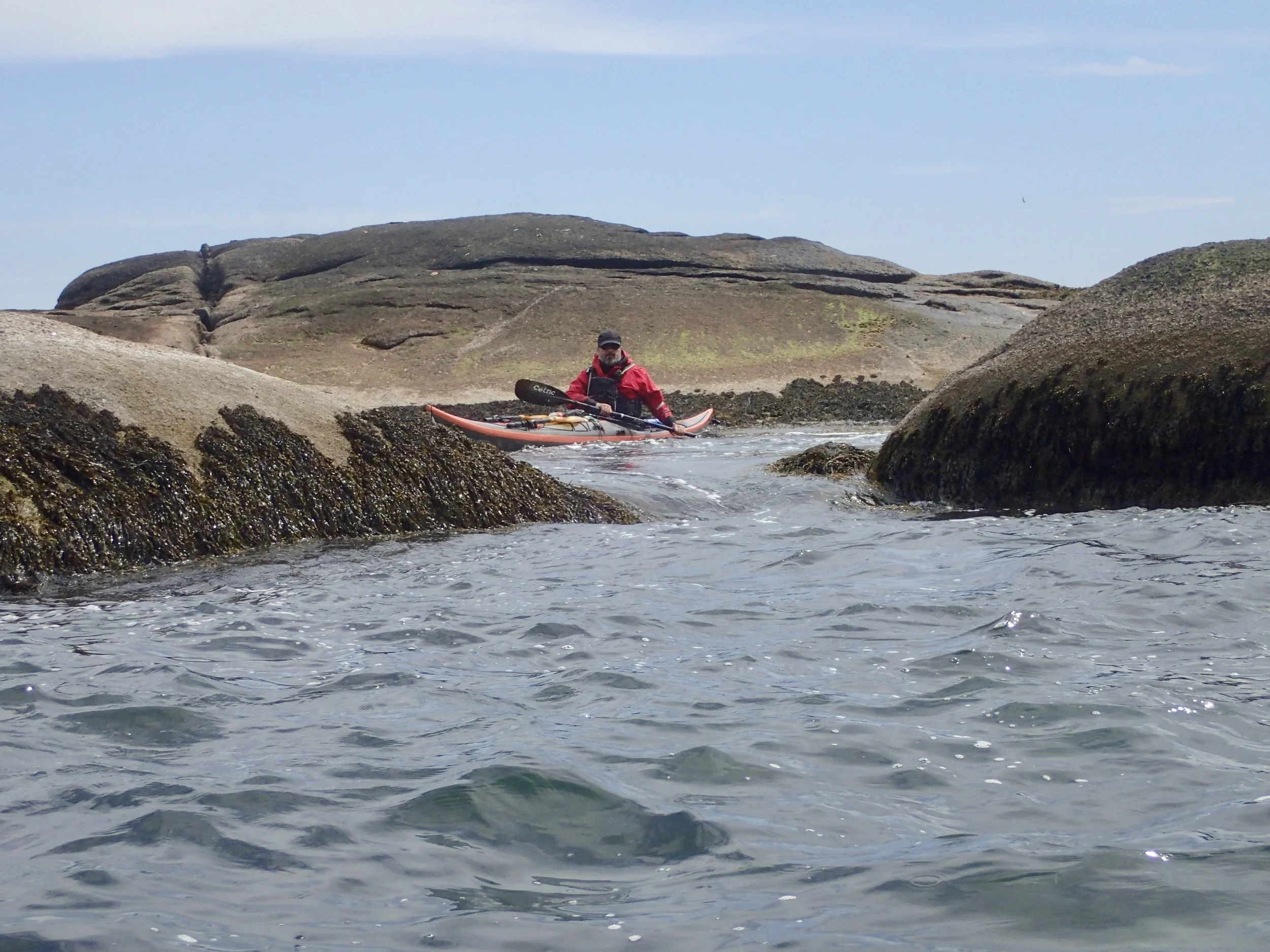 Kayak navigating between rocks