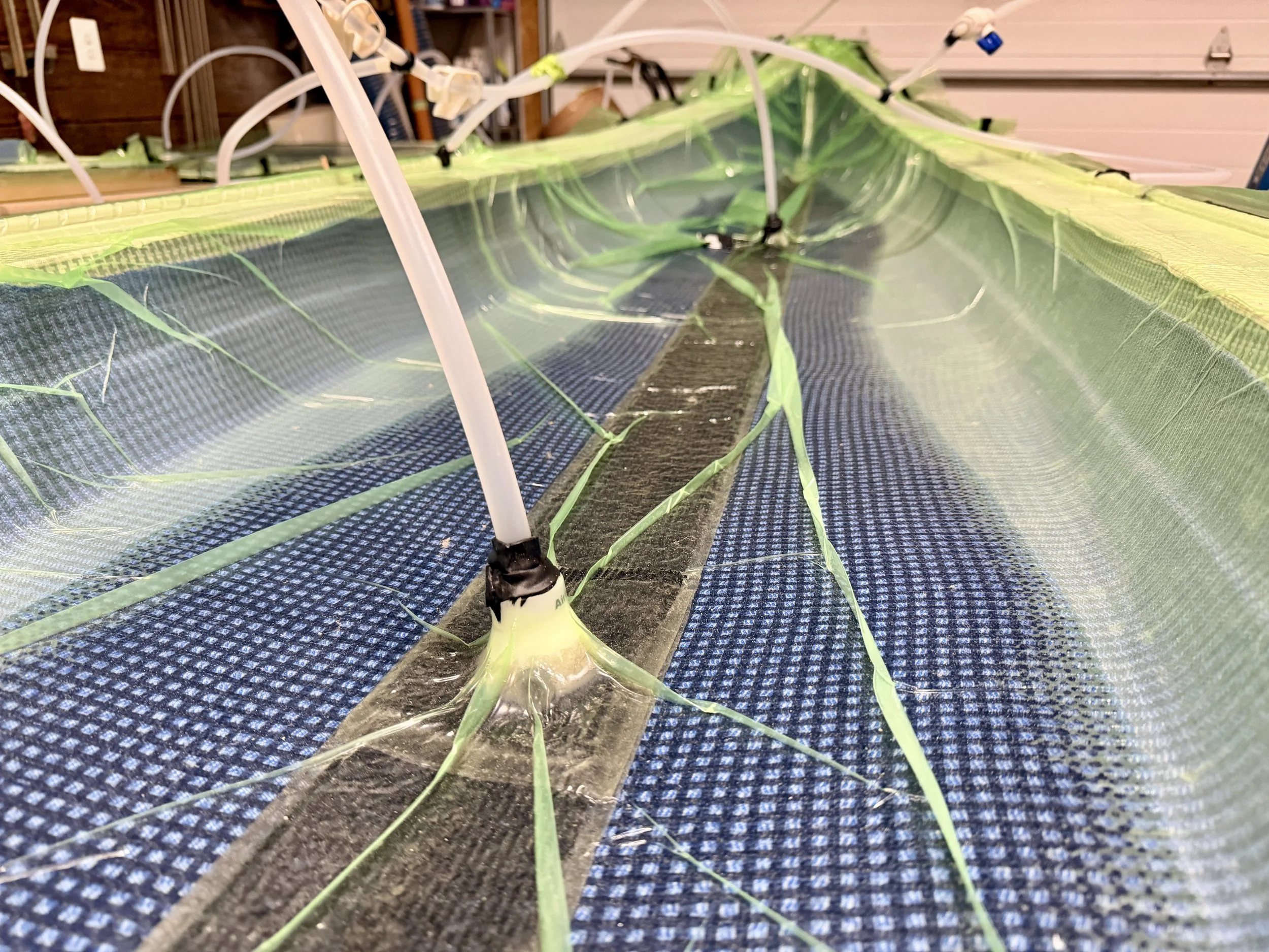 Close-up view of a hydroponic system with green plants growing in a water-filled container, with white tubing and black fixtures.