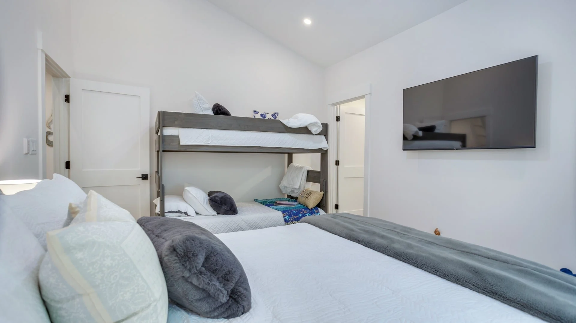 Bedroom with bunk beds, single bed, and wall-mounted TV
