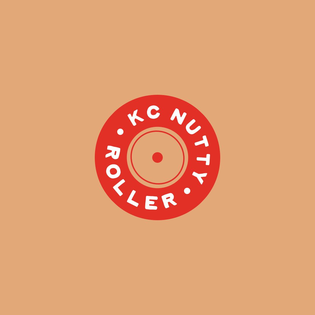 A circular red roller skate wheel with the words "K.C NUTTY ROLLER" written around the edge.