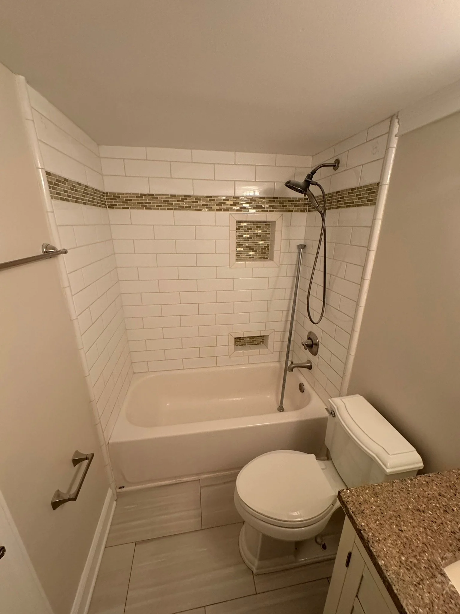 Bathroom upgrade - Tile tub/shower surround with accent, paint, and flooring. 