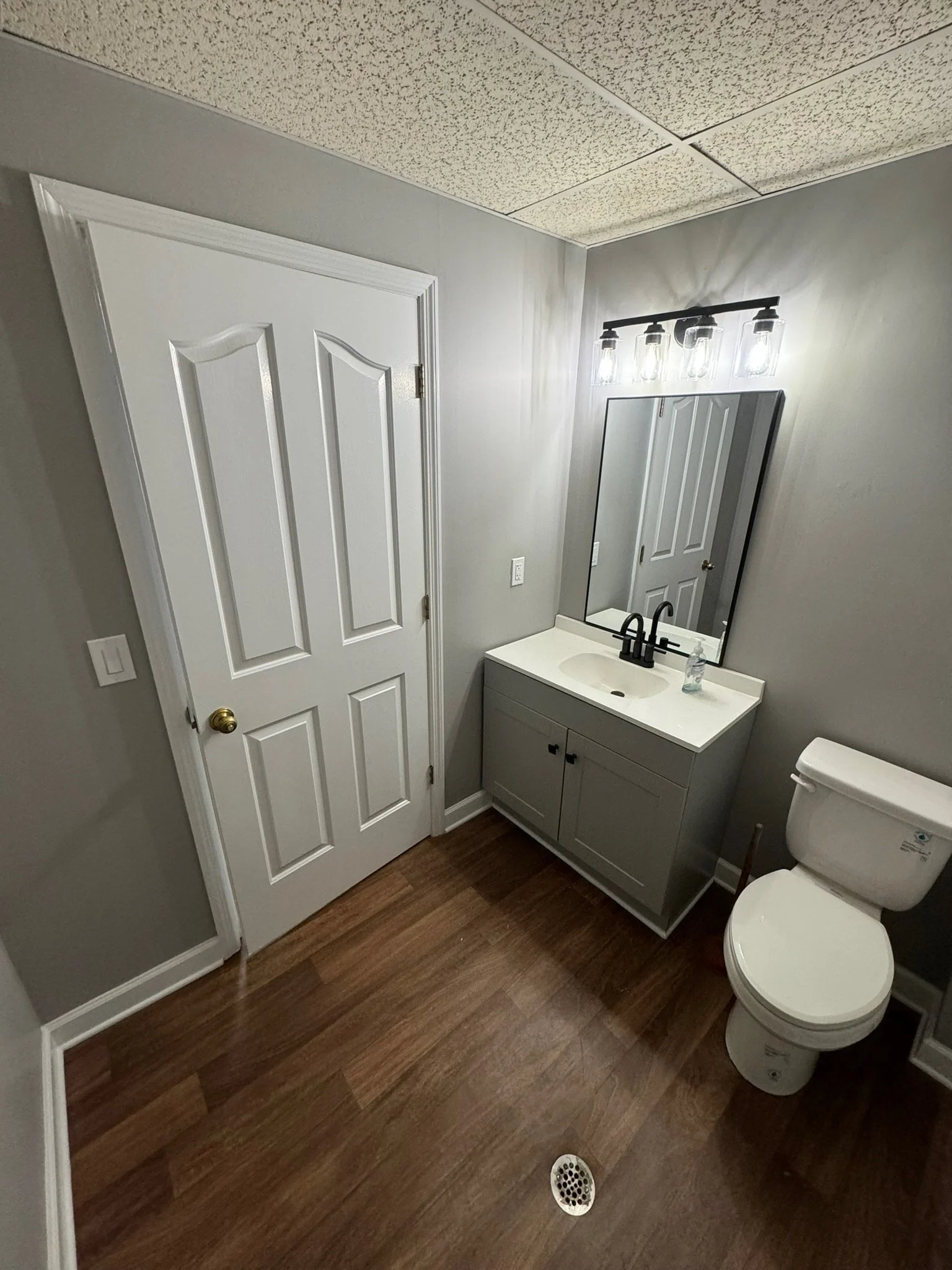 Warehouse office bathroom upgrade - new vanity, mirror, and light, flooring, and paint. 