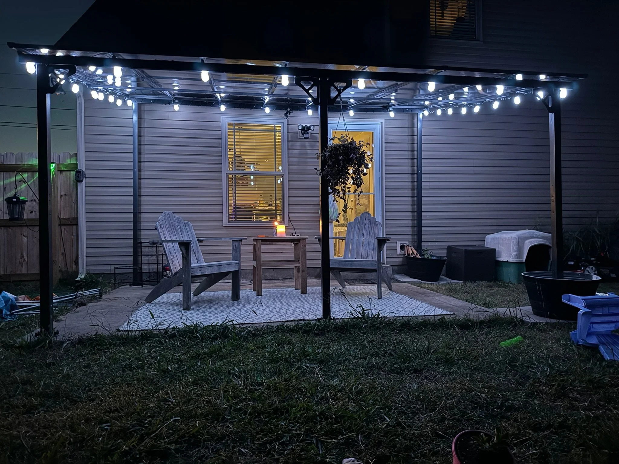 Pergola kit assembled and installed, with string lights added. 