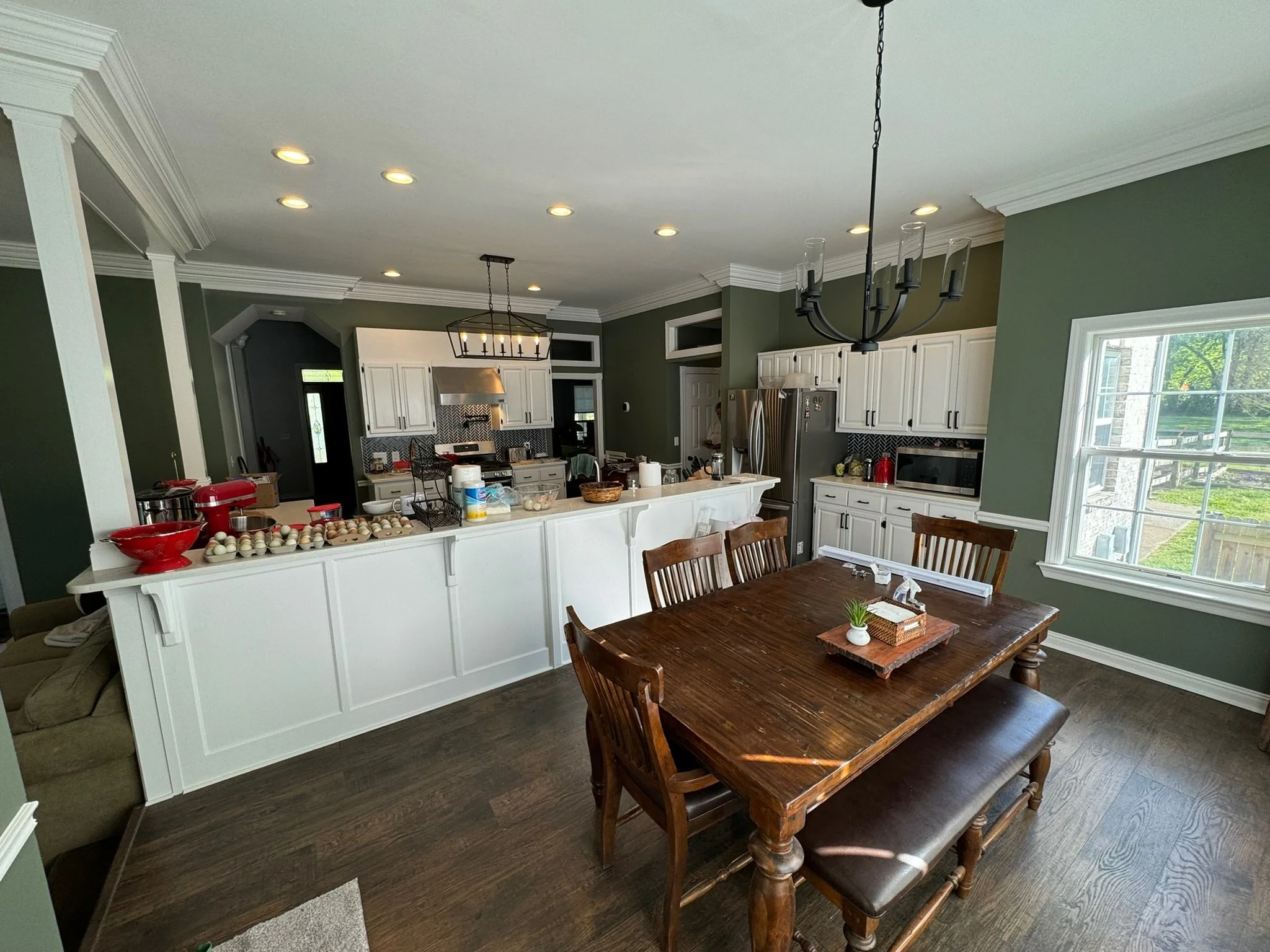 Color-change repaint from dull neutrals to a lush green, with crisp white trim and an updated dining room chandelier. 