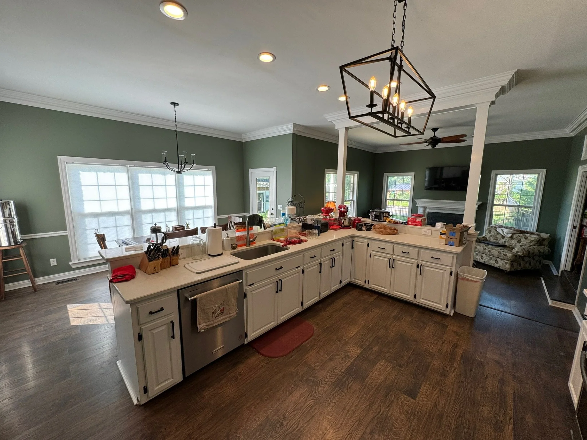 Color-change repaint from dull neutrals to a lush green, with crisp white trim and an updated dining room chandelier. 