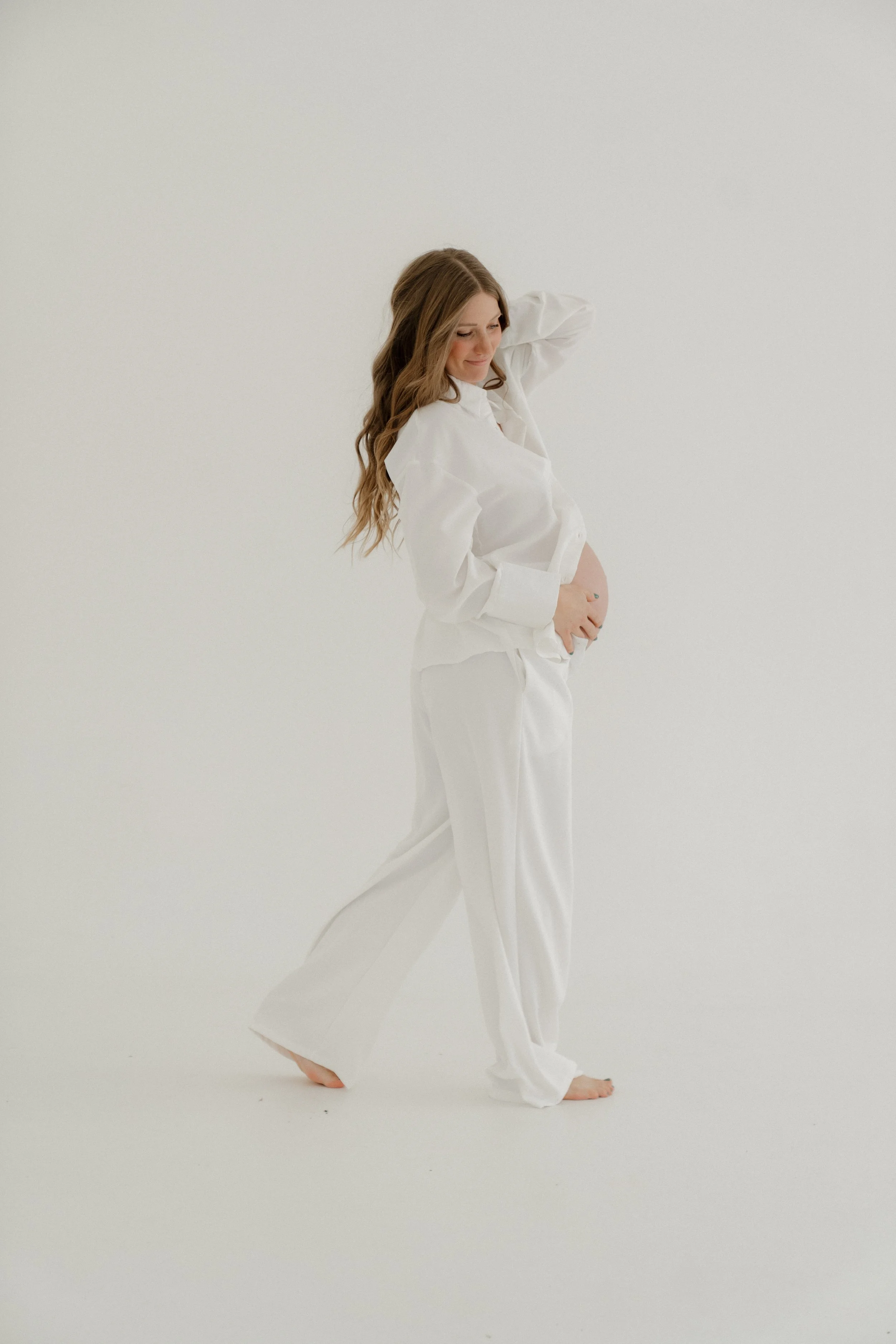 Expecting mother in flowing white dress during a maternity photography session in Sarasota, Florida.