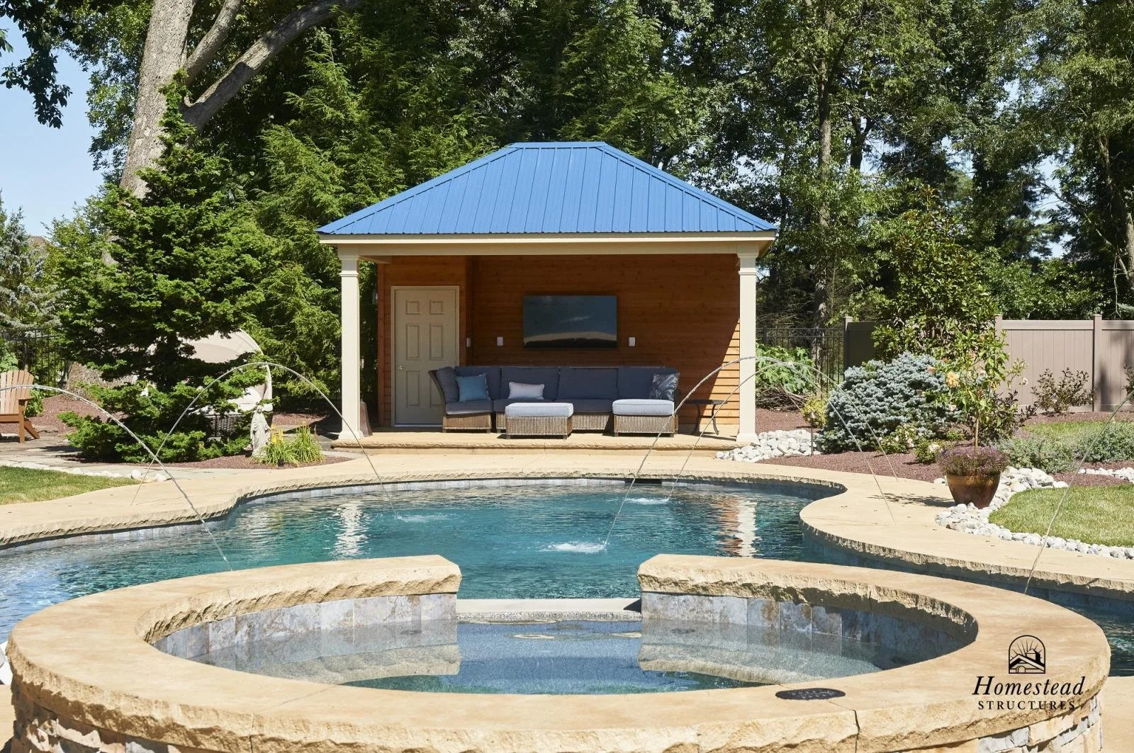 A backyard with a swimming pool and a poolside pavilion with outdoor seating, trees, and landscaping.