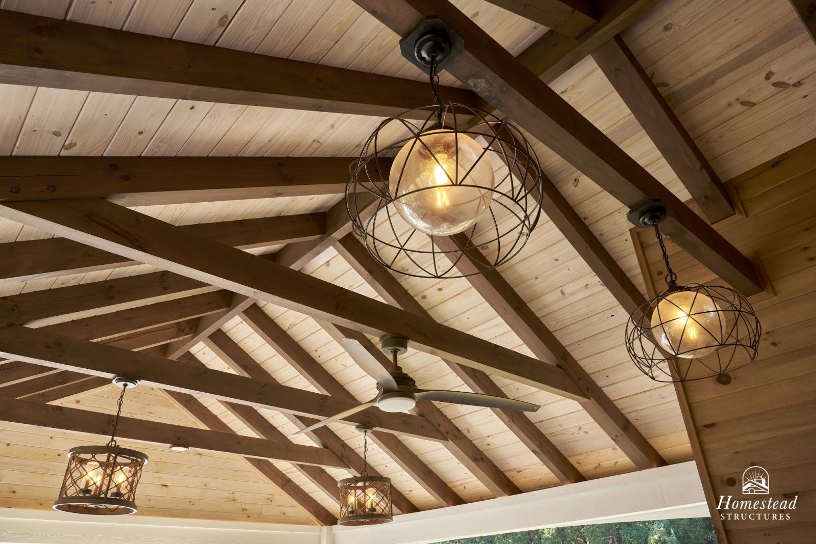 Ceiling with exposed wooden beams, hanging decorative light fixtures, and a ceiling fan.