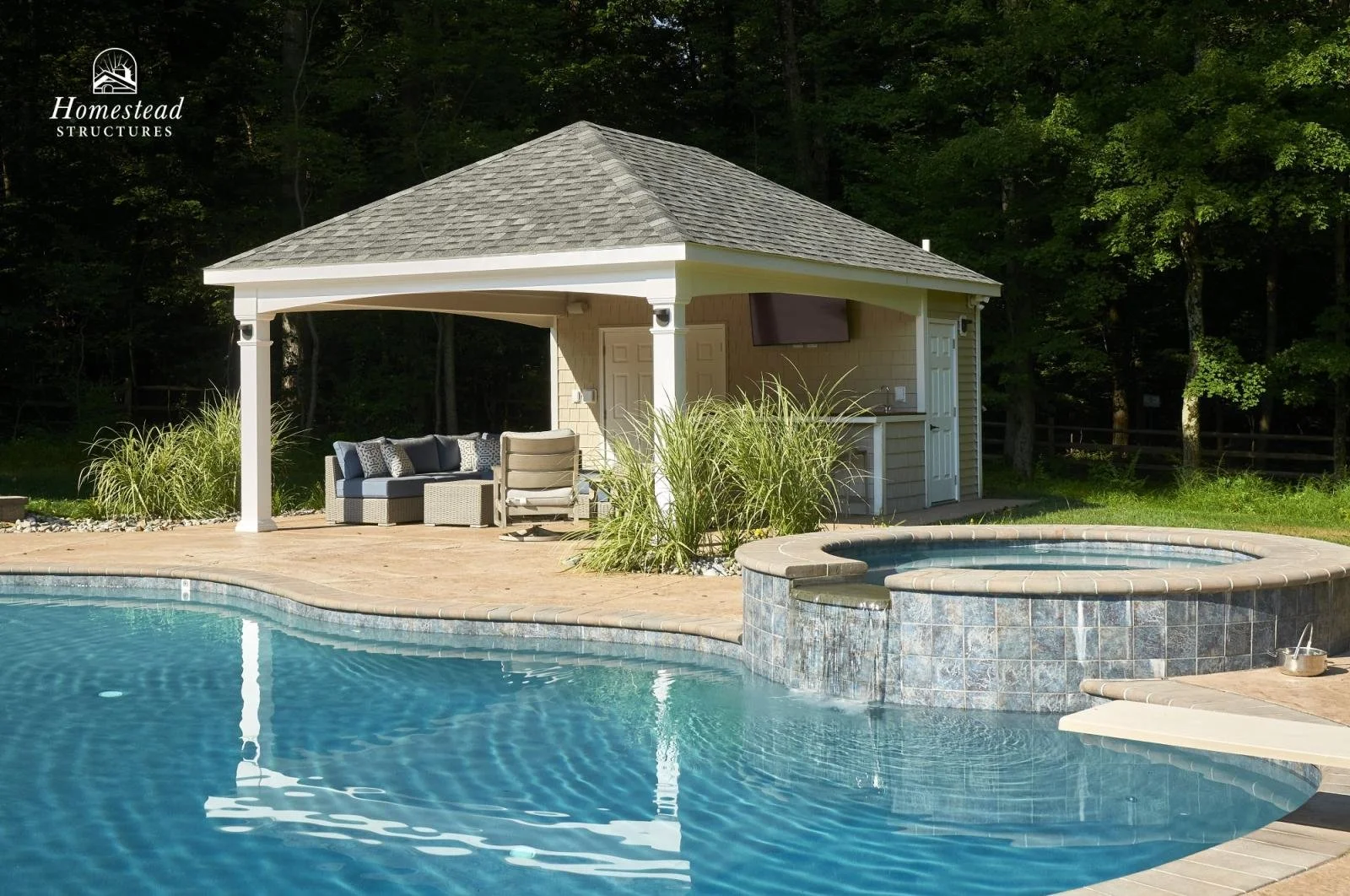 An outdoor pool area with a pool, a hot tub, and a gazebo in a backyard with trees in the background.