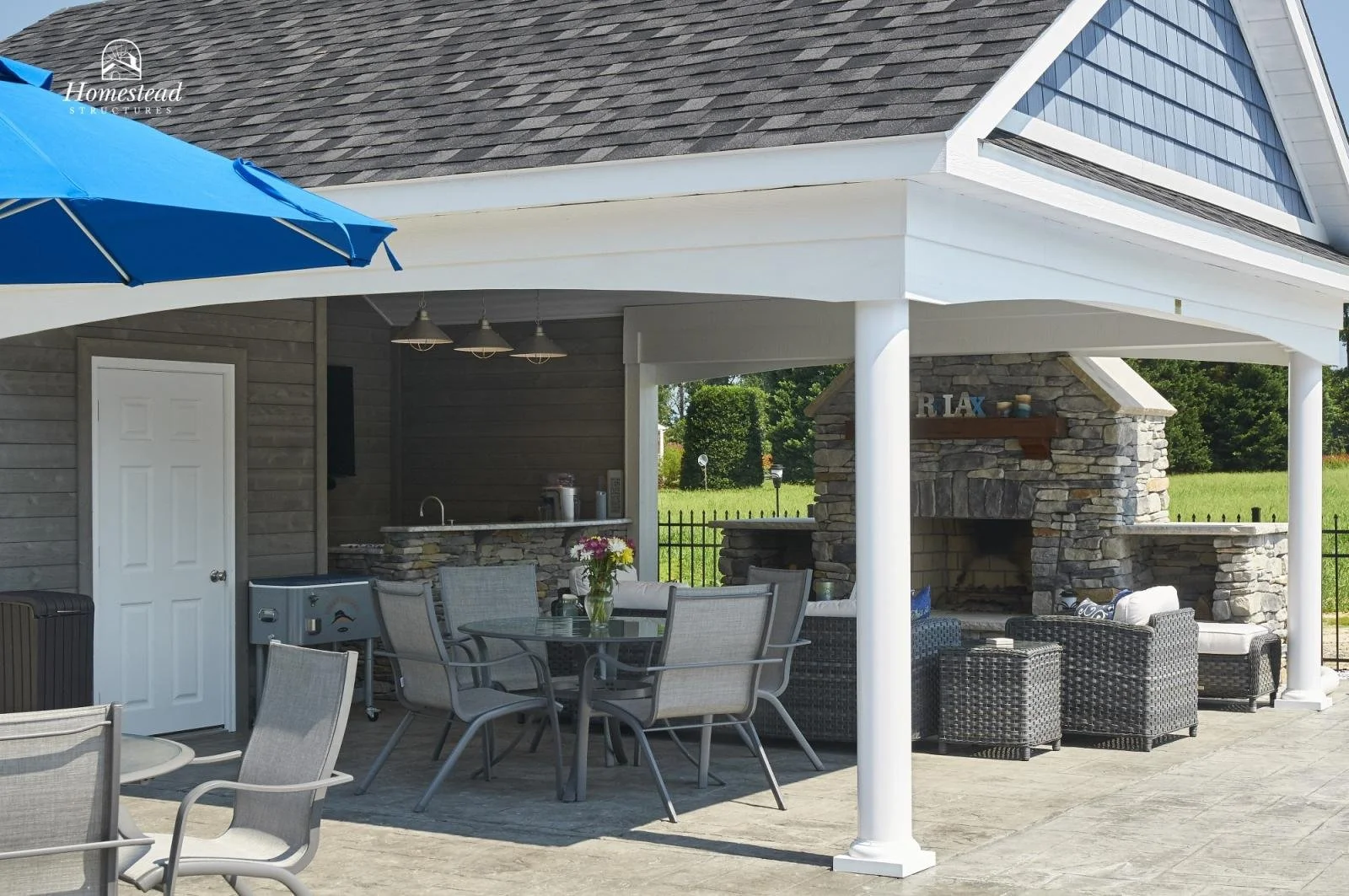 Outdoor patio area with dining table, chairs, and outdoor fireplace.