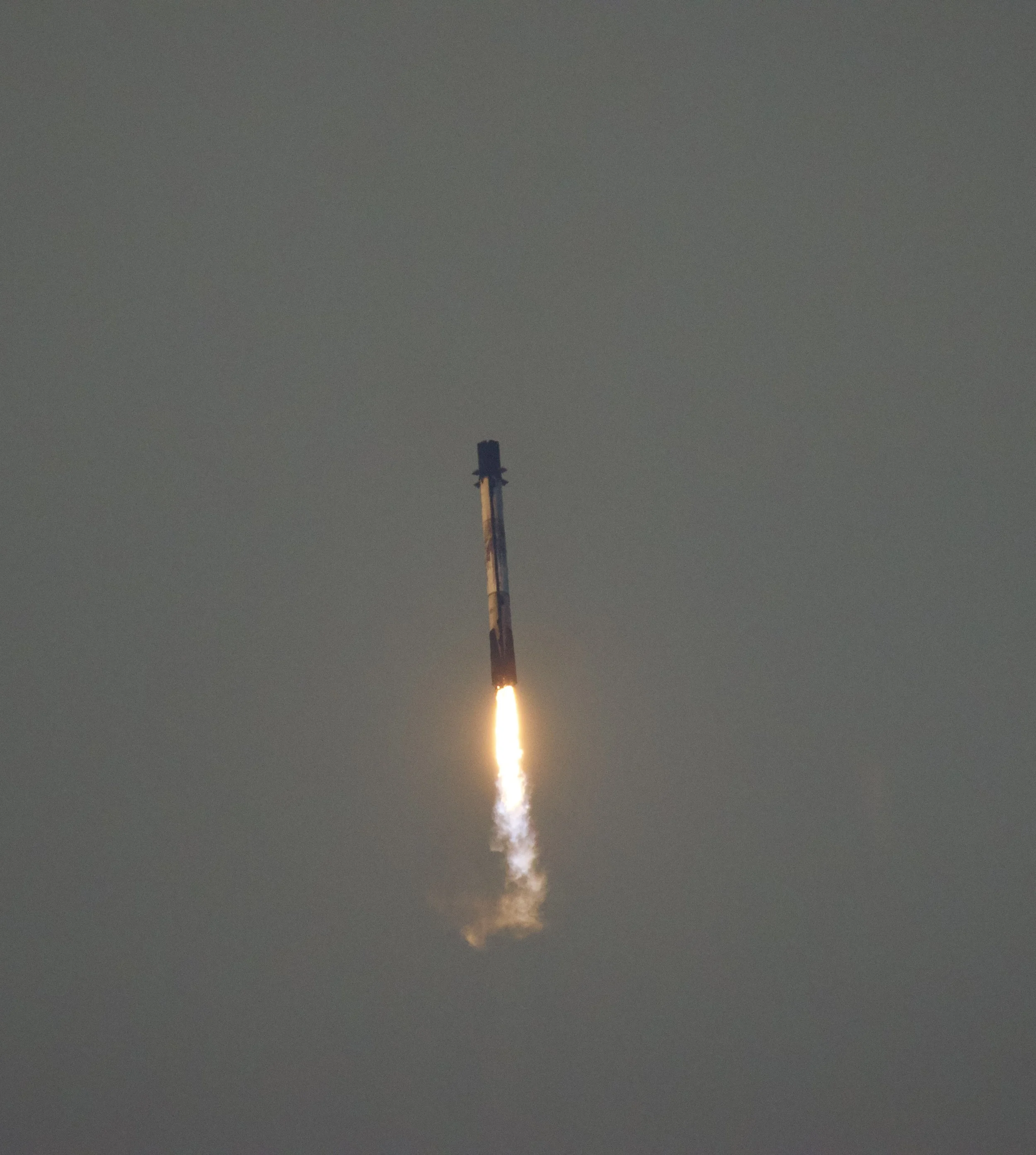 A rocket launching into the sky with flames and smoke at the base.