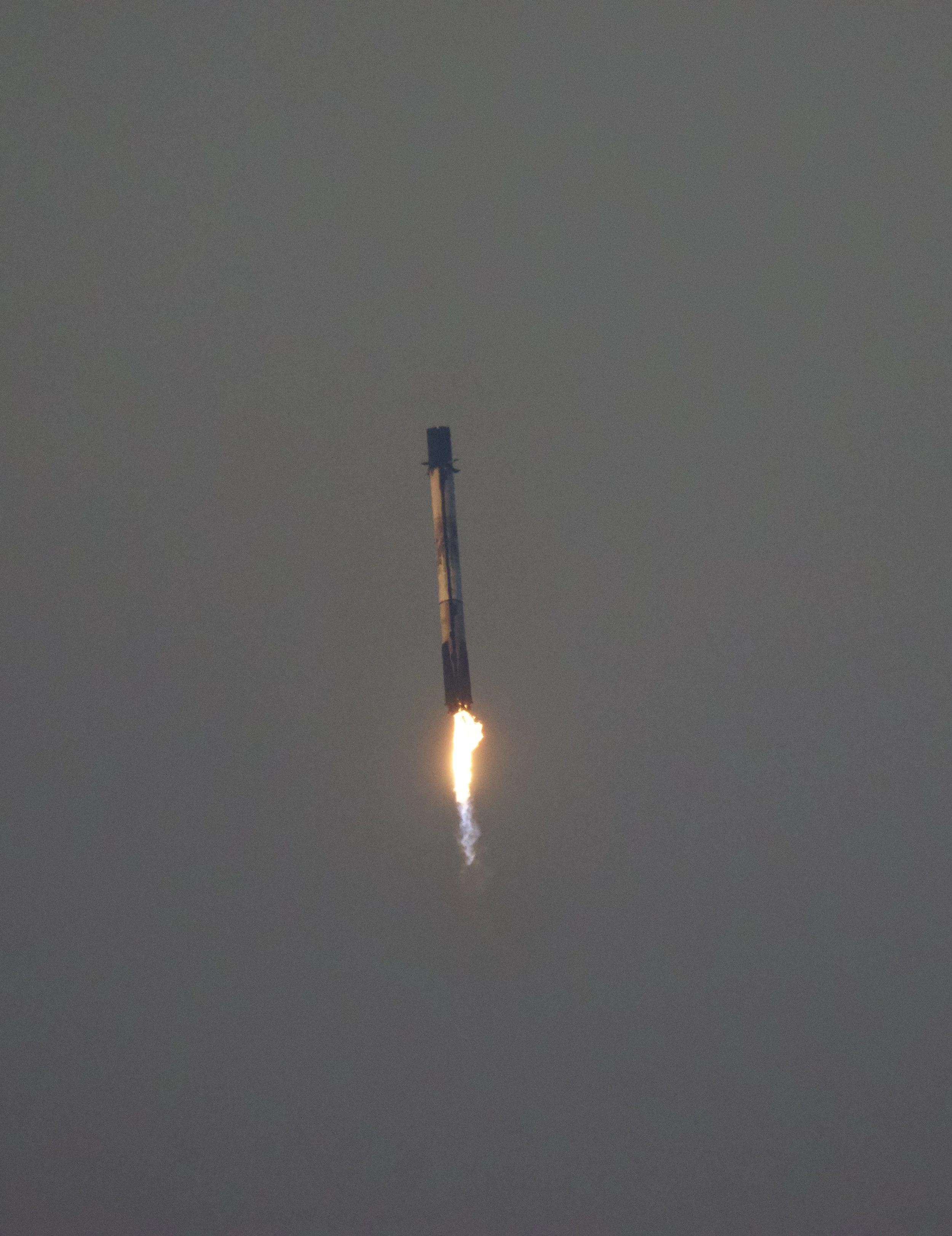 A rocket launching with a visible flame and smoke at the bottom, ascending into the sky.