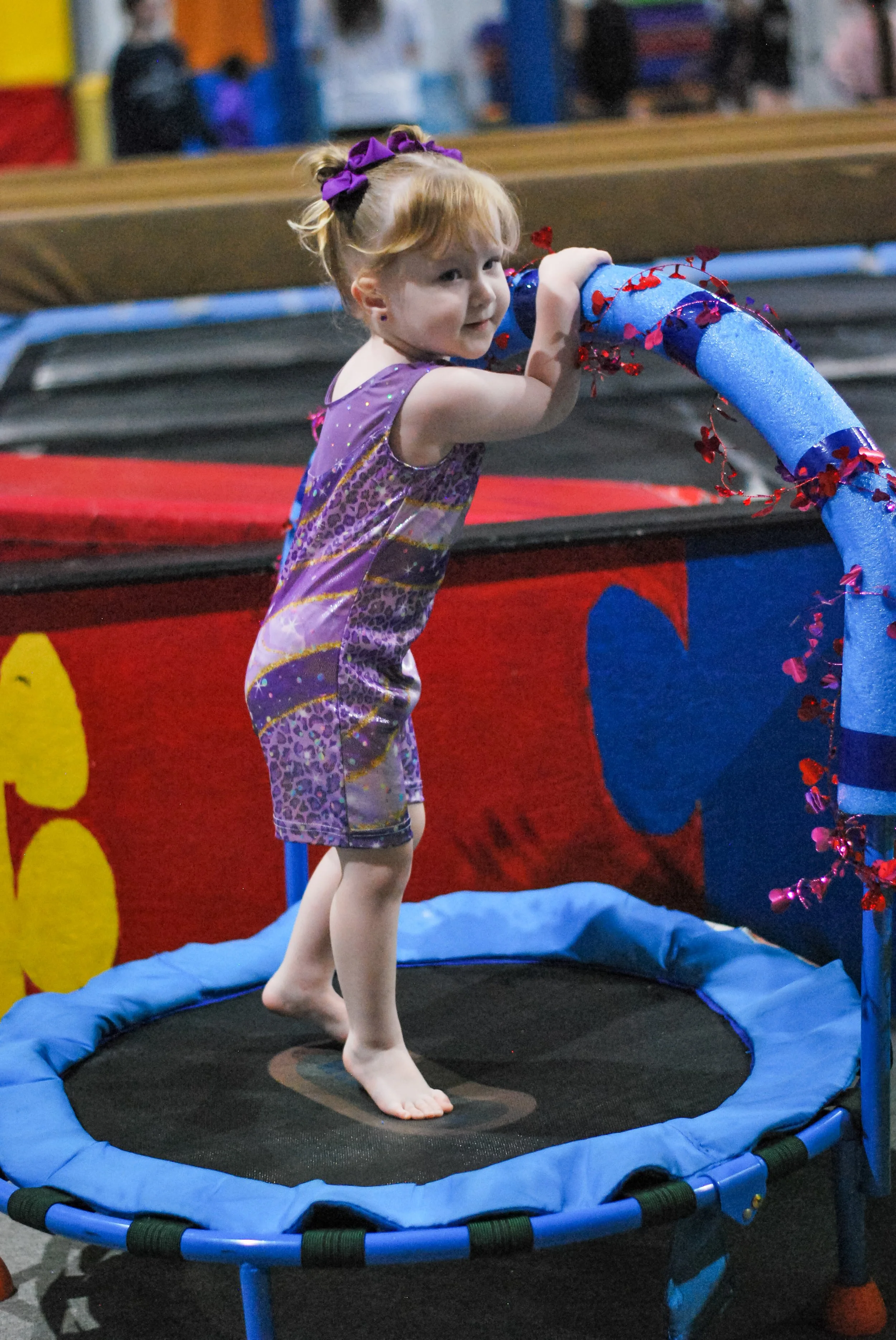 Gymnastics bounding baby on trampoline
