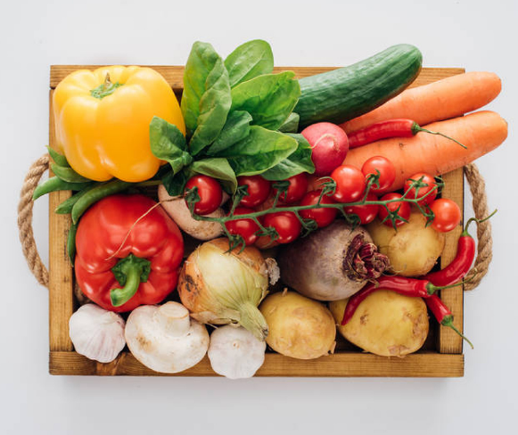 Fresh vegetables in a wooden crate representing the Cosori Lite 4.0-quart smart air fryer for compact kitchens.