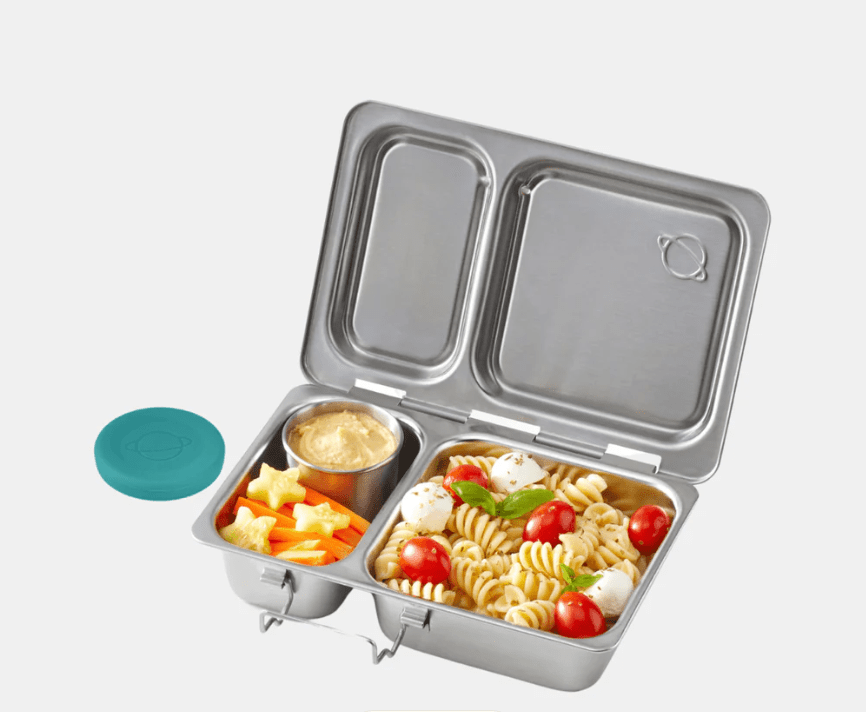 Stainless steel PlanetBox lunchbox filled with pasta salad, cheese, and fresh fruit.