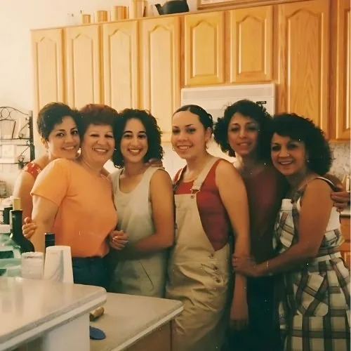 The author with family. Two are wearing aprons. They're standing in a kitchen in front of cabinets and a white microwave. They're smiling.