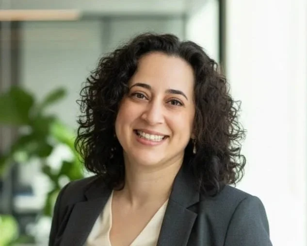 Photo of Veronica Allende, founder and CEO of healthwealth. She's smiling, and her dark hair is curled around her face.