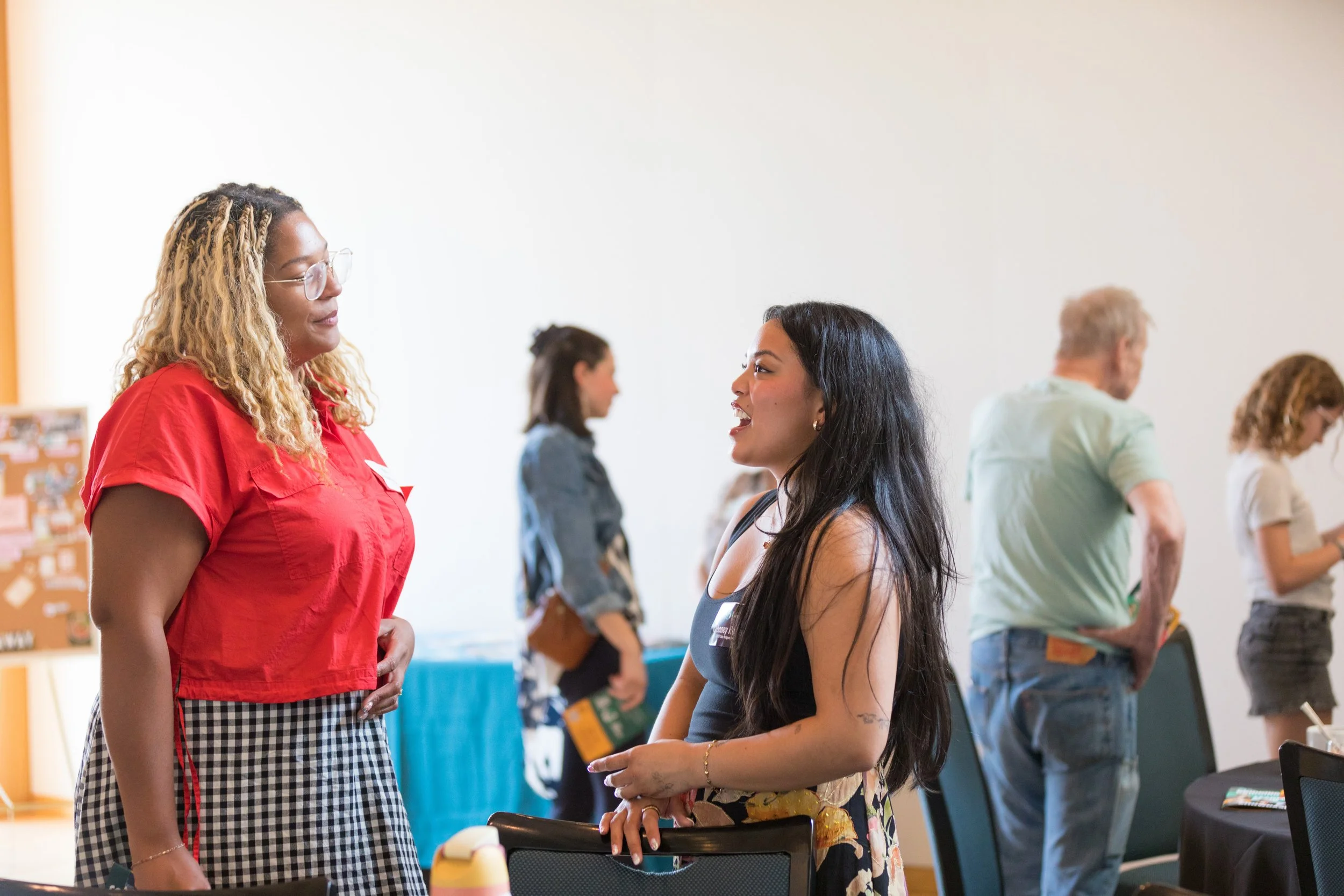  A guest speaks with a current fellow about her project. 