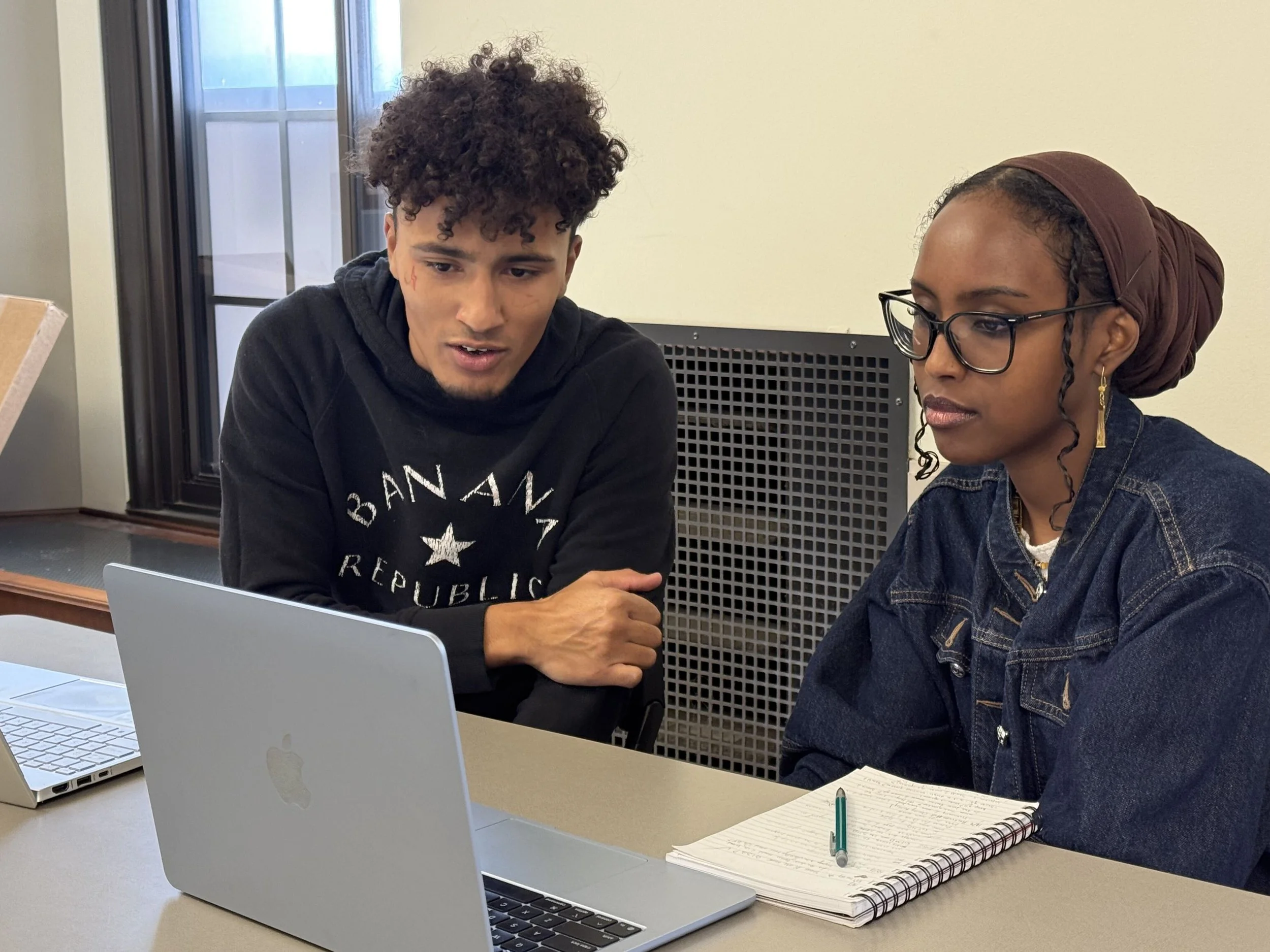 Two Fellows workshop survey questions around a laptop.