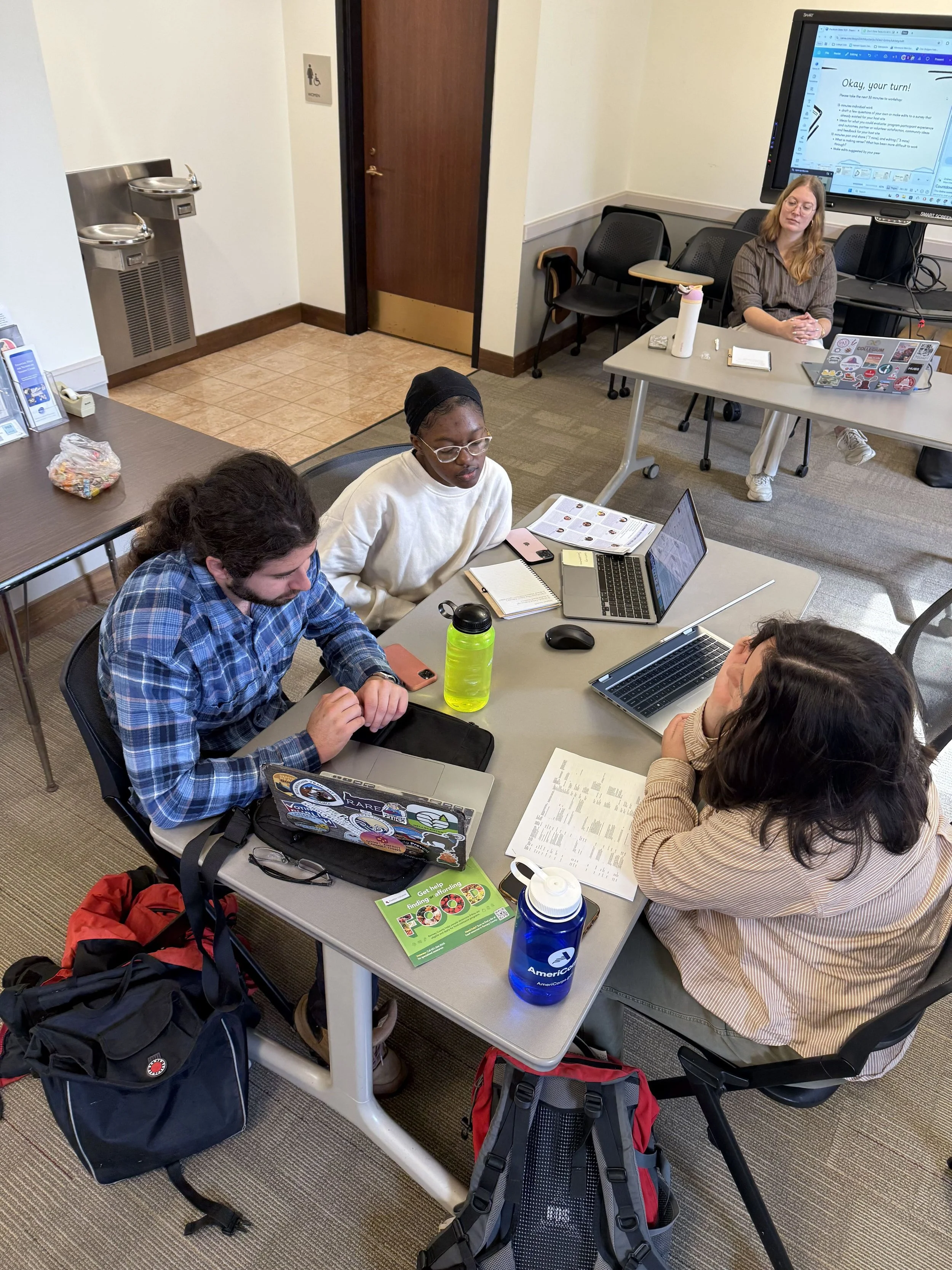A group of Fellows sits around a table discussing their surveys.