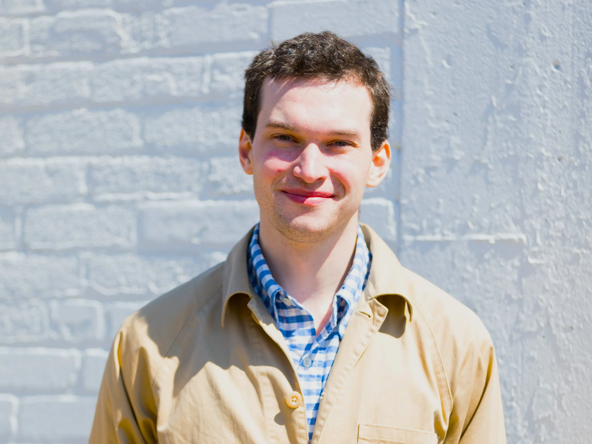 Headshot of Senior Fellow, George Lefkowicz, against the backdrop of a white brick wall.