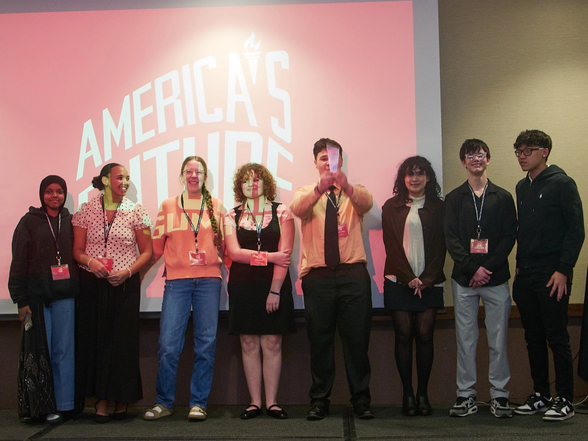 A group of 8 young people smile at the camera.