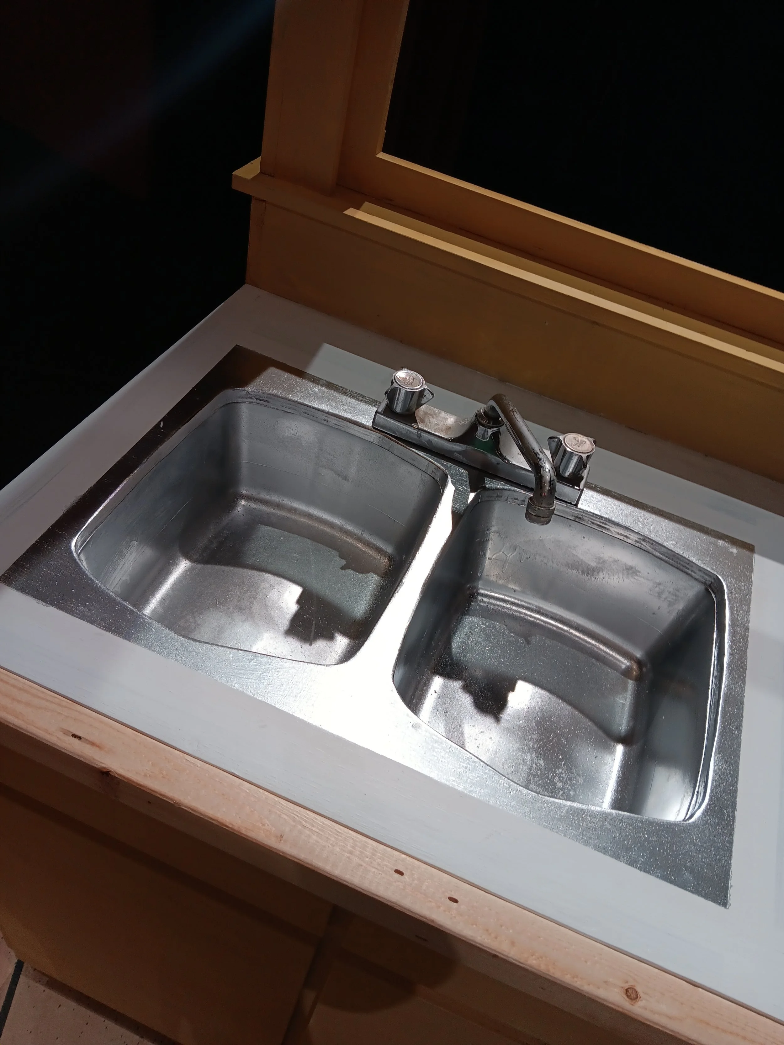 Sink made from spray painted plastic bins to save money.