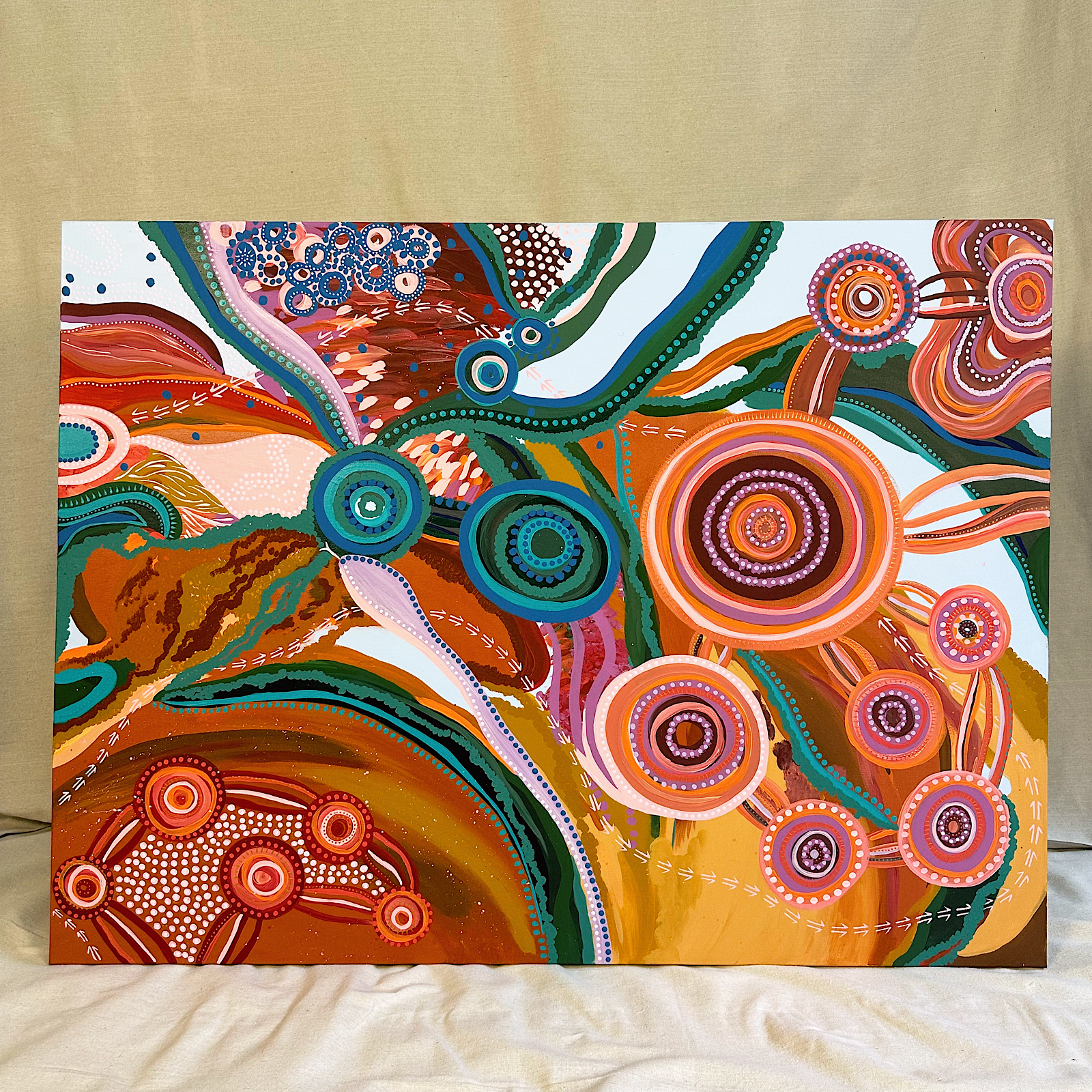 Colorful abstract painting with circular patterns, swirls, and dots in shades of orange, pink, blue, green, and brown.