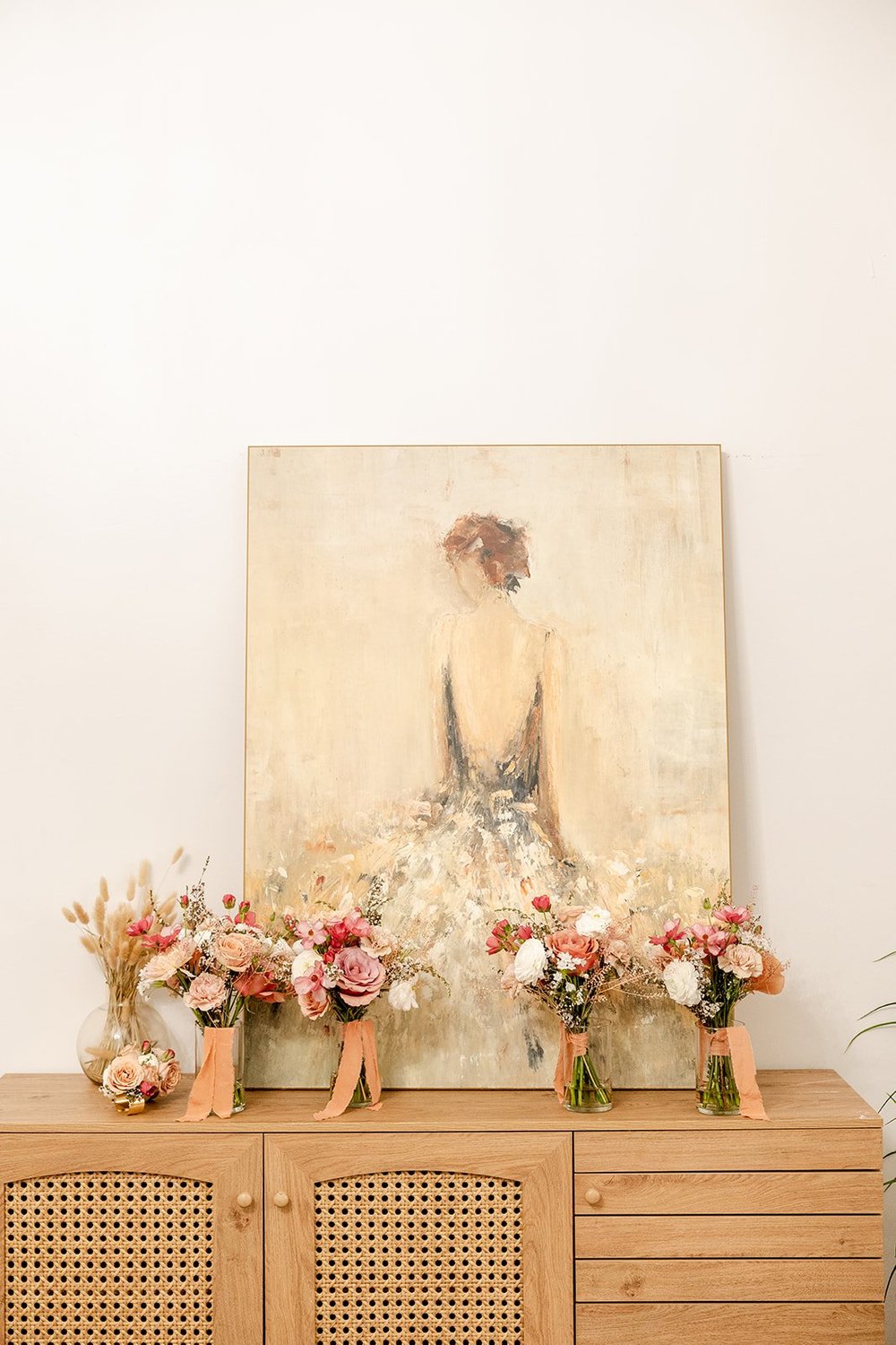 console with painting and bridesmaids bouquets