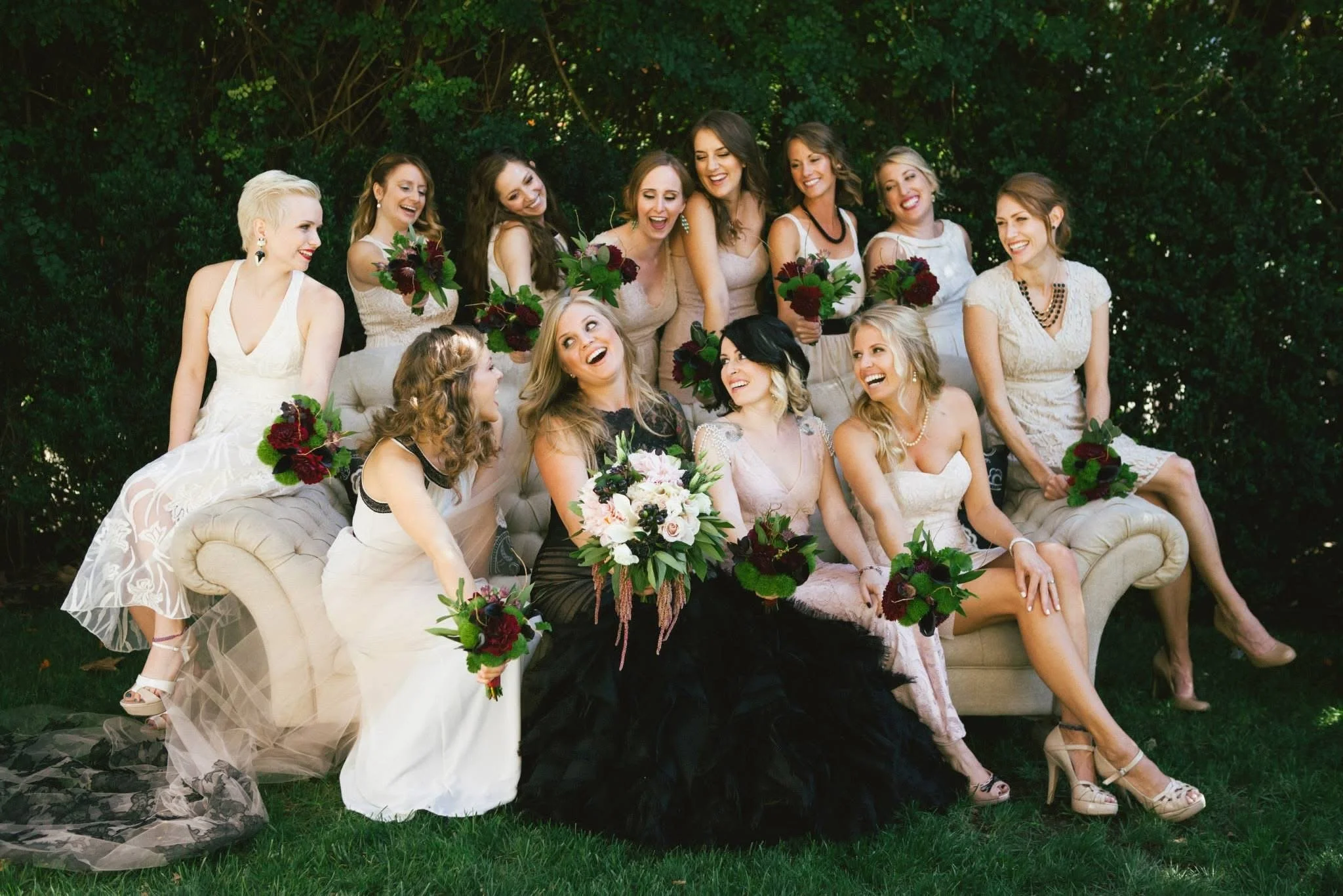bride wearing black mermaid style wedding gown surrounded by her bridesmaids in their bridesmaids dresses