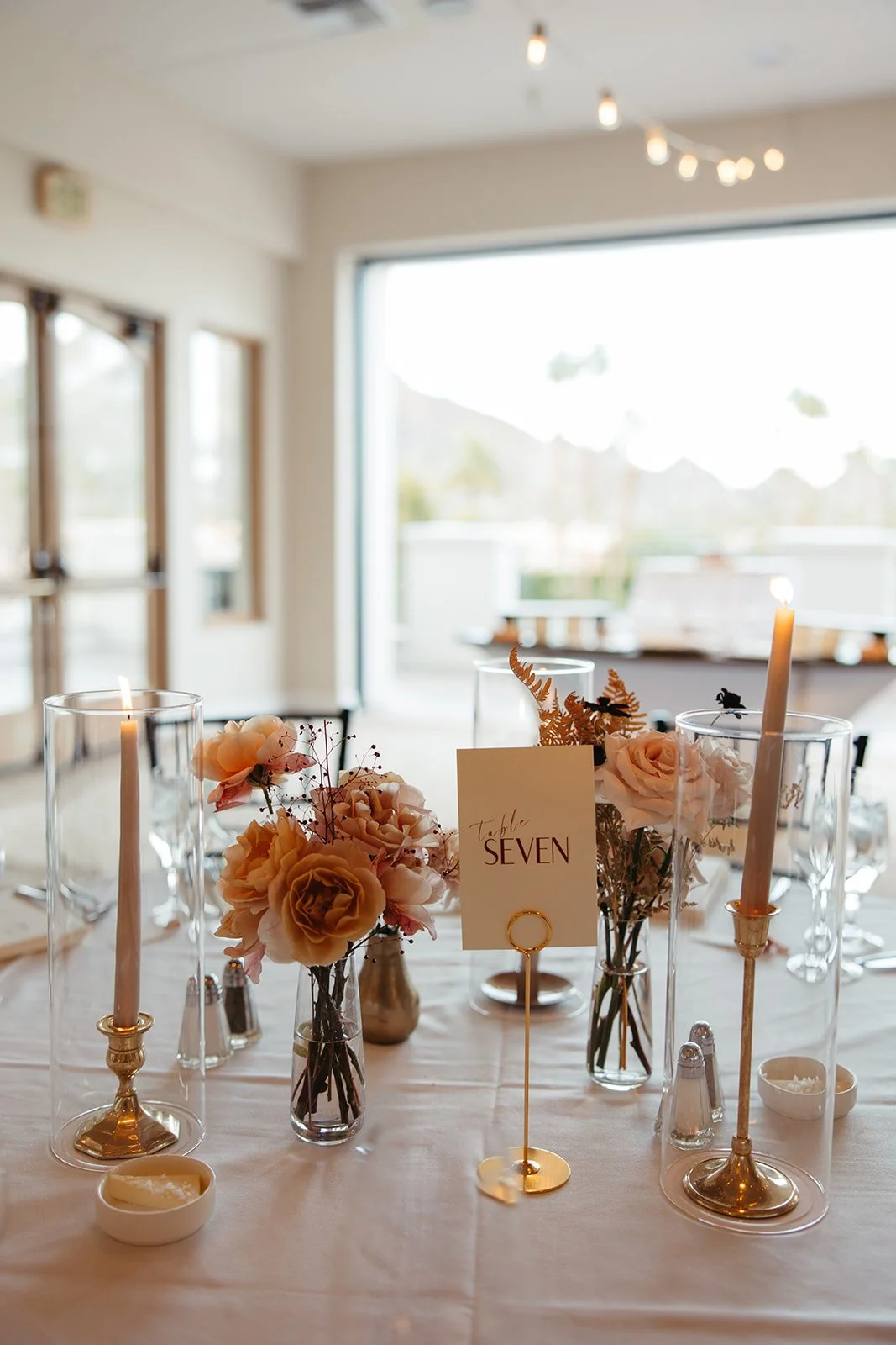  Intimate reception table with soft candlelight, bud vase florals, neutral linens, and airy seasonal blooms designed for a November wedding at La Quinta Resort. 