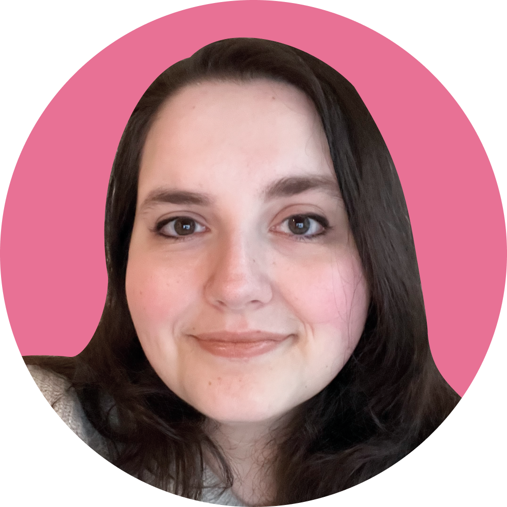 Close-up of a young woman with dark hair, smiling, against a pink background.