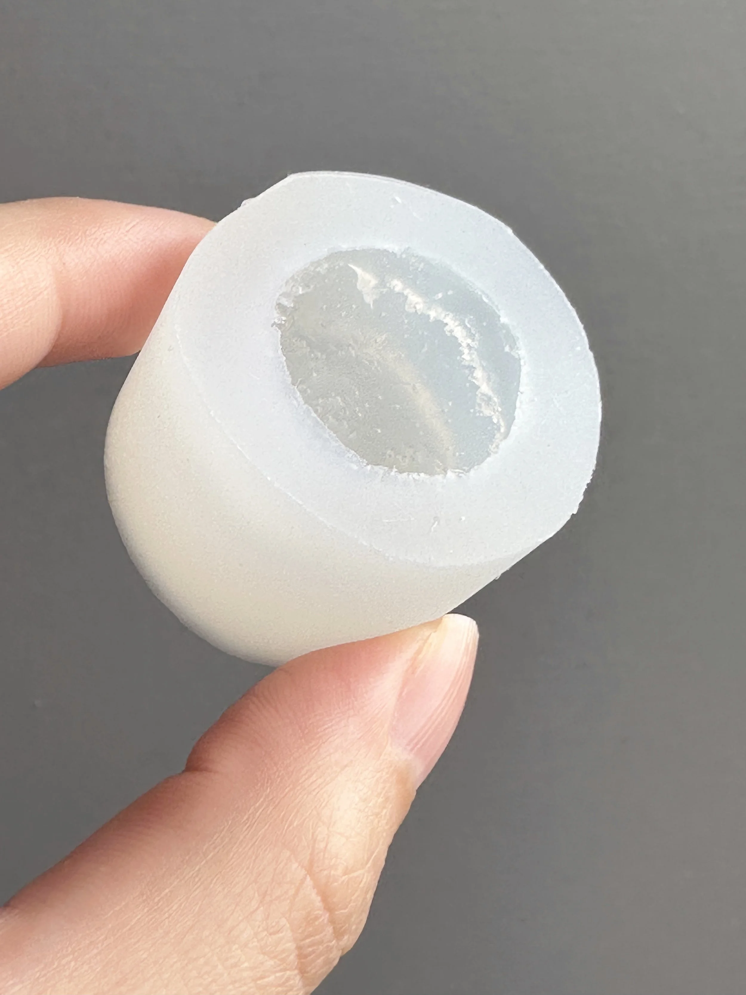 Fingers holding a biscuit silicone mold.