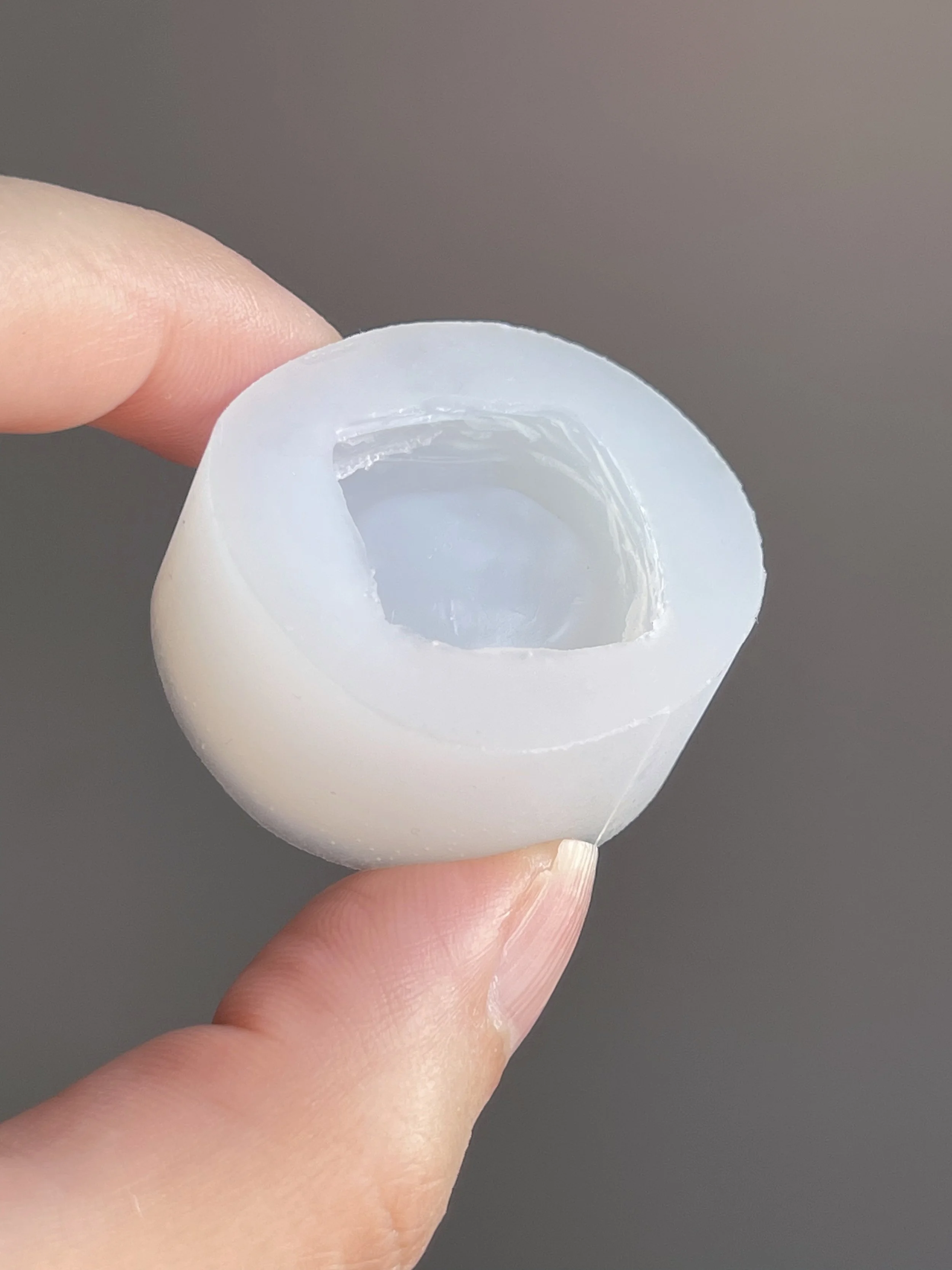 Fingers holding a clear danish pastry silicone mold.