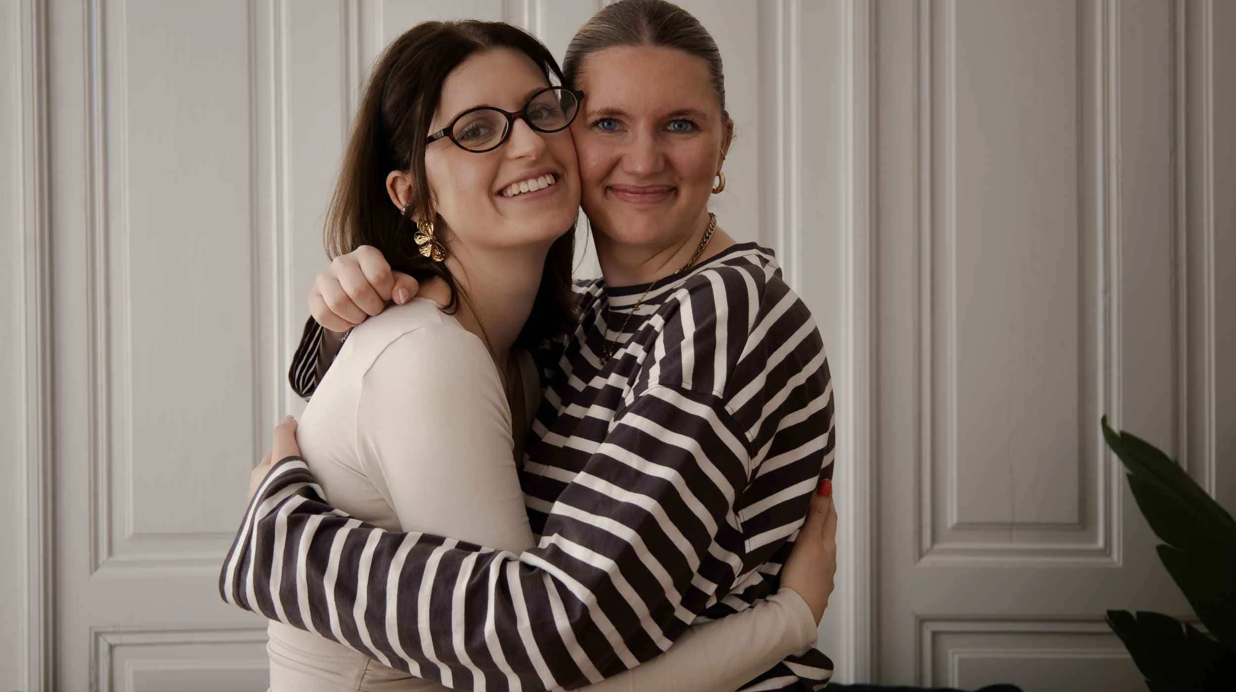 Zwei Frauen umarmen sich und vermitteln Nähe, Vertrauen und Unterstützung.
