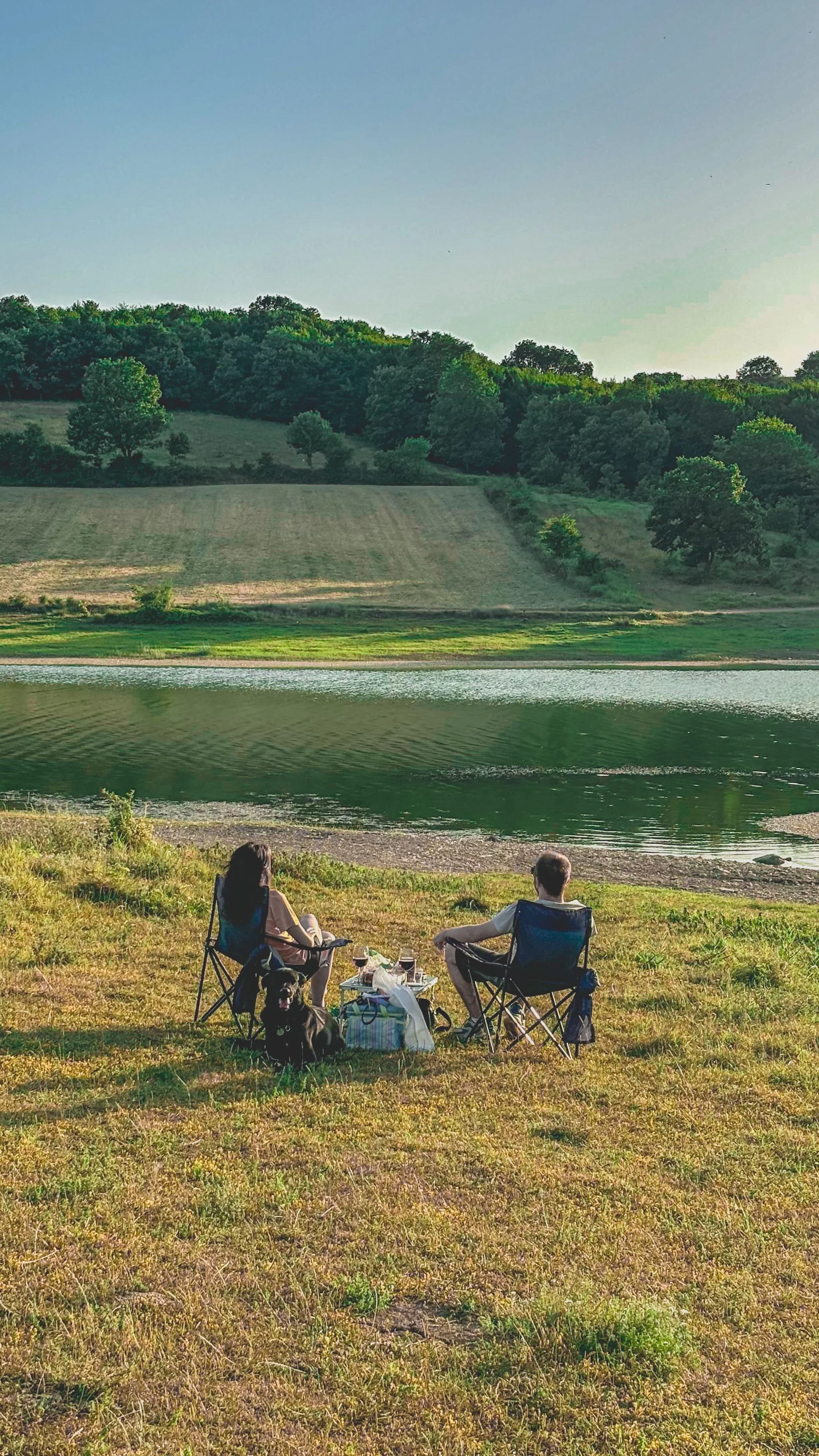 Paar entspannt mit Hund am See – Erholung und neue Energie nach einem Burnout