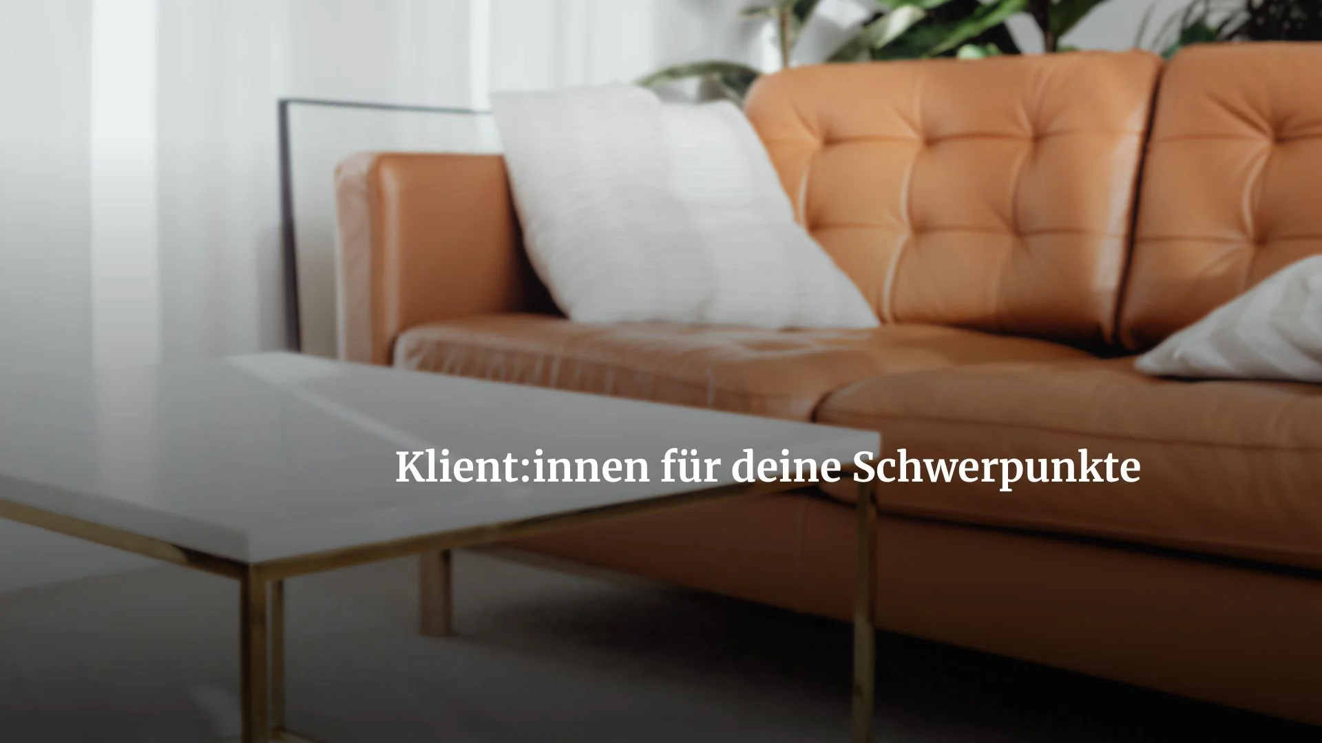 Ein Wohnzimmer mit einem orangefarbenen Ledersofa mit weißen Kissen und einem weißen Couchtisch.