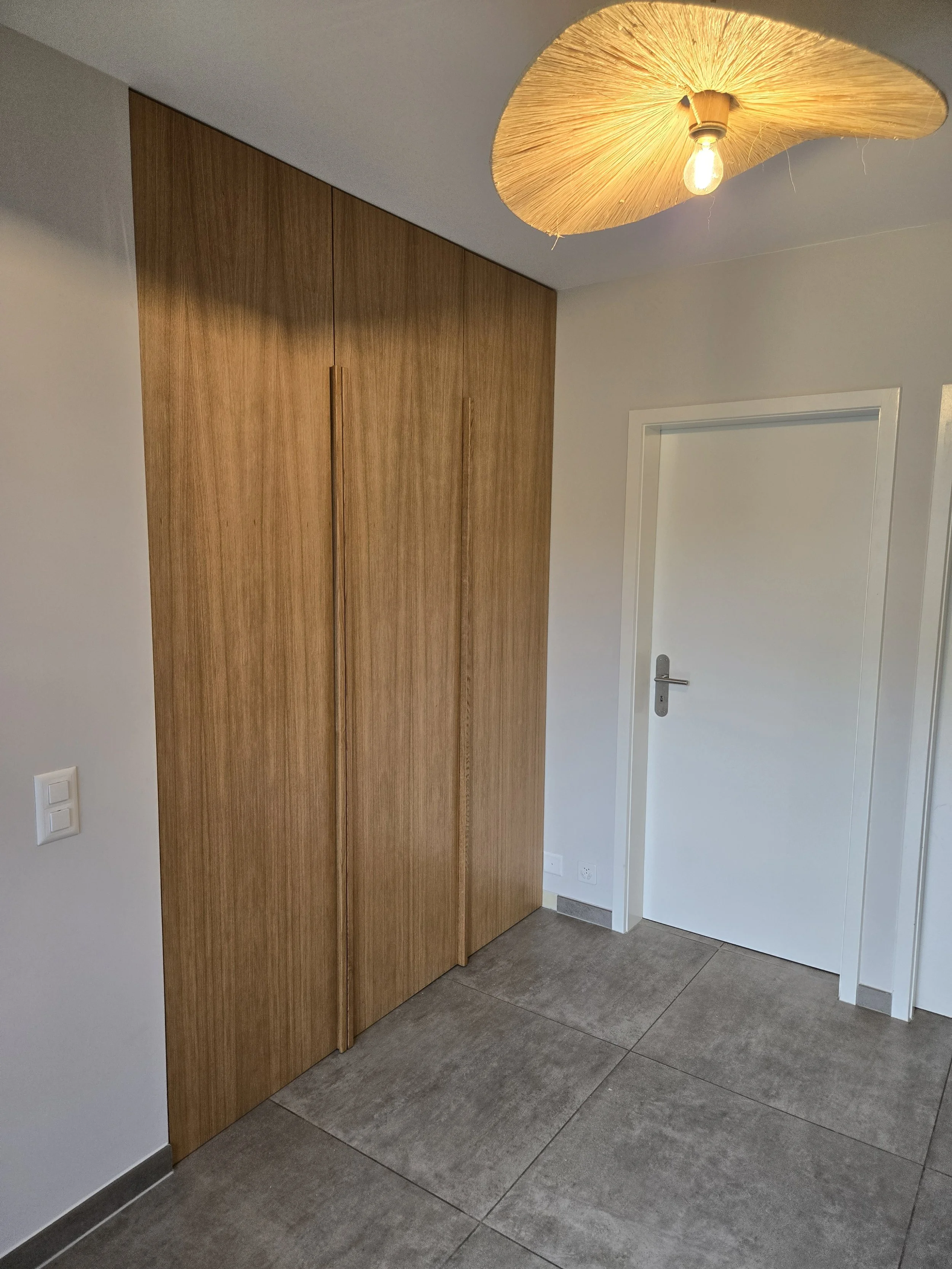 Dressing hall d'entrée, portes sol plafond plaquées en chêne, poignée en chêne massif, intérieur blanc avec tiroirs, penderies, lifts pour habits et chaussures, travail artisanal, ébénisterie Sauthier