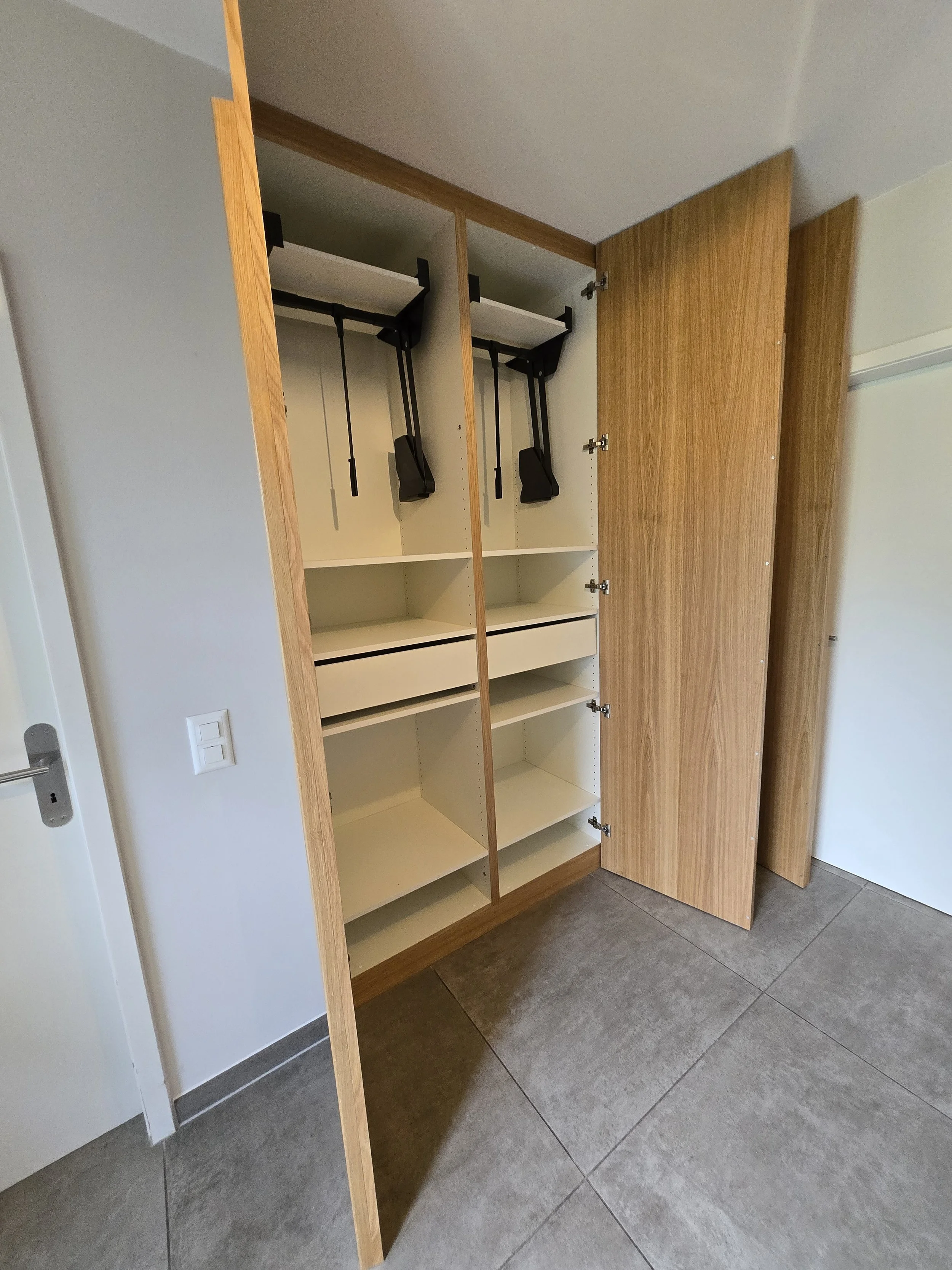 Dressing hall d'entrée, portes sol plafond plaquées en chêne, poignée en chêne massif, intérieur blanc avec tiroirs, penderies, lifts pour habits et chaussures, travail artisanal, ébénisterie Sauthier