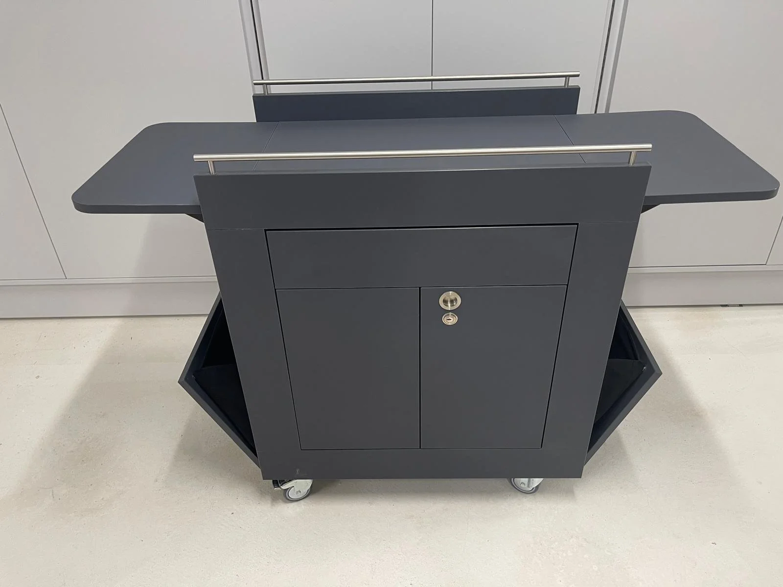 Chariot de présentation, médiation musée, en stratifié gris, avec tiroir, abattants latéraux, portes avec serrures, soufflets en tissu sur les côtés, ébénisterie Sauthier