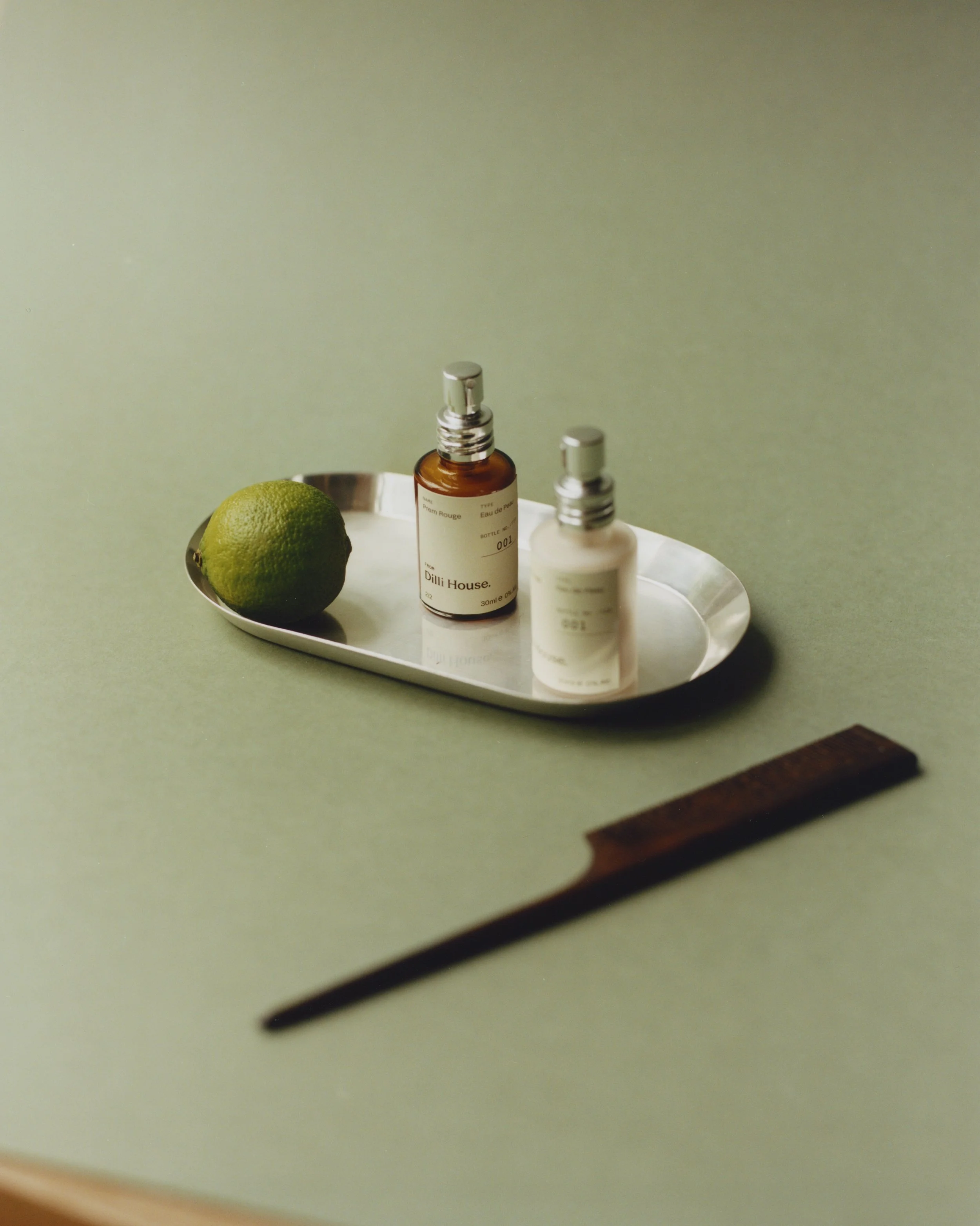Prem Rouge Eau de Peau natural fragrance duo styled on a tray with lime by Dilli House