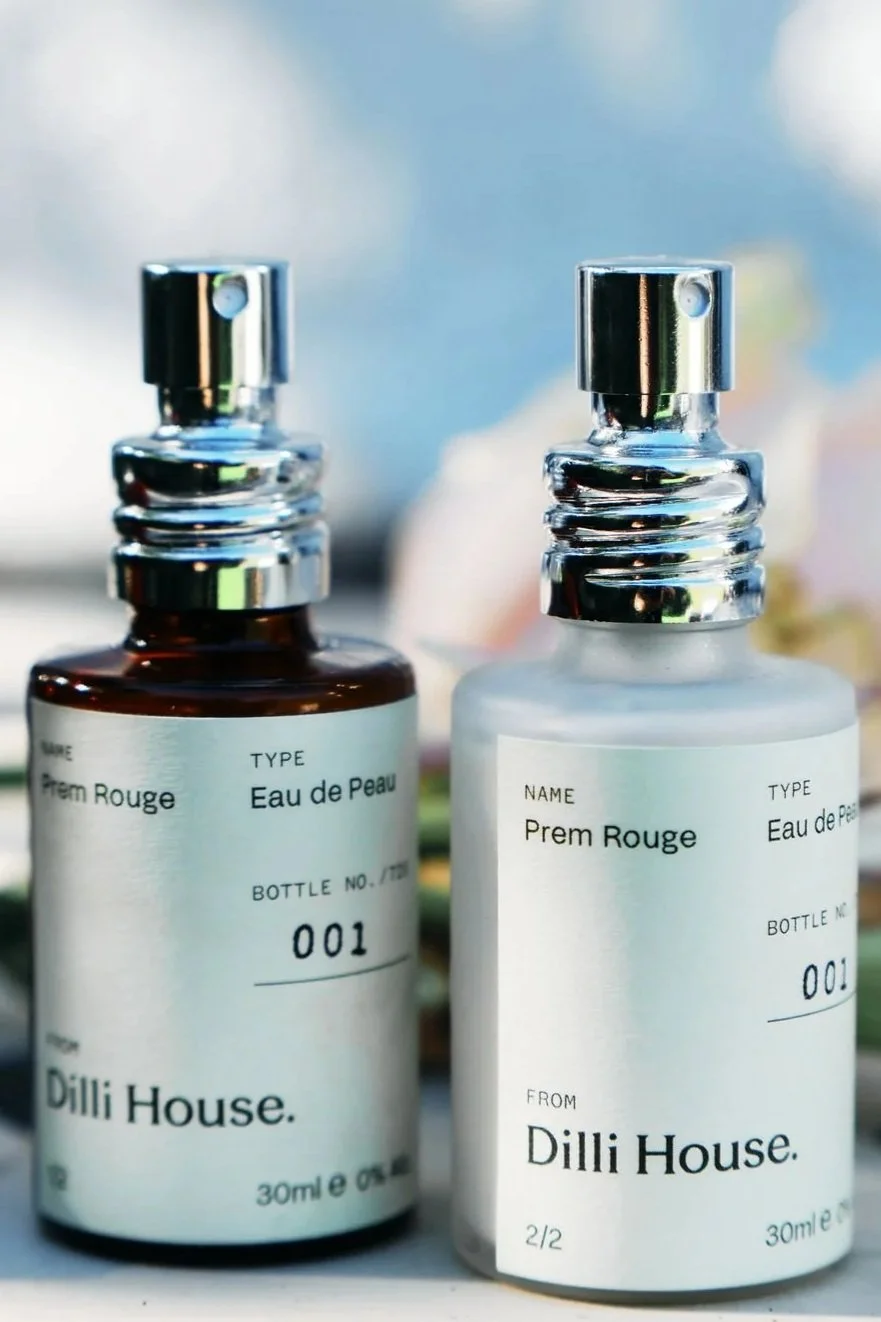 Two bottles of Prem Rouge, numbered 001, in a natural, outdoor setting.
