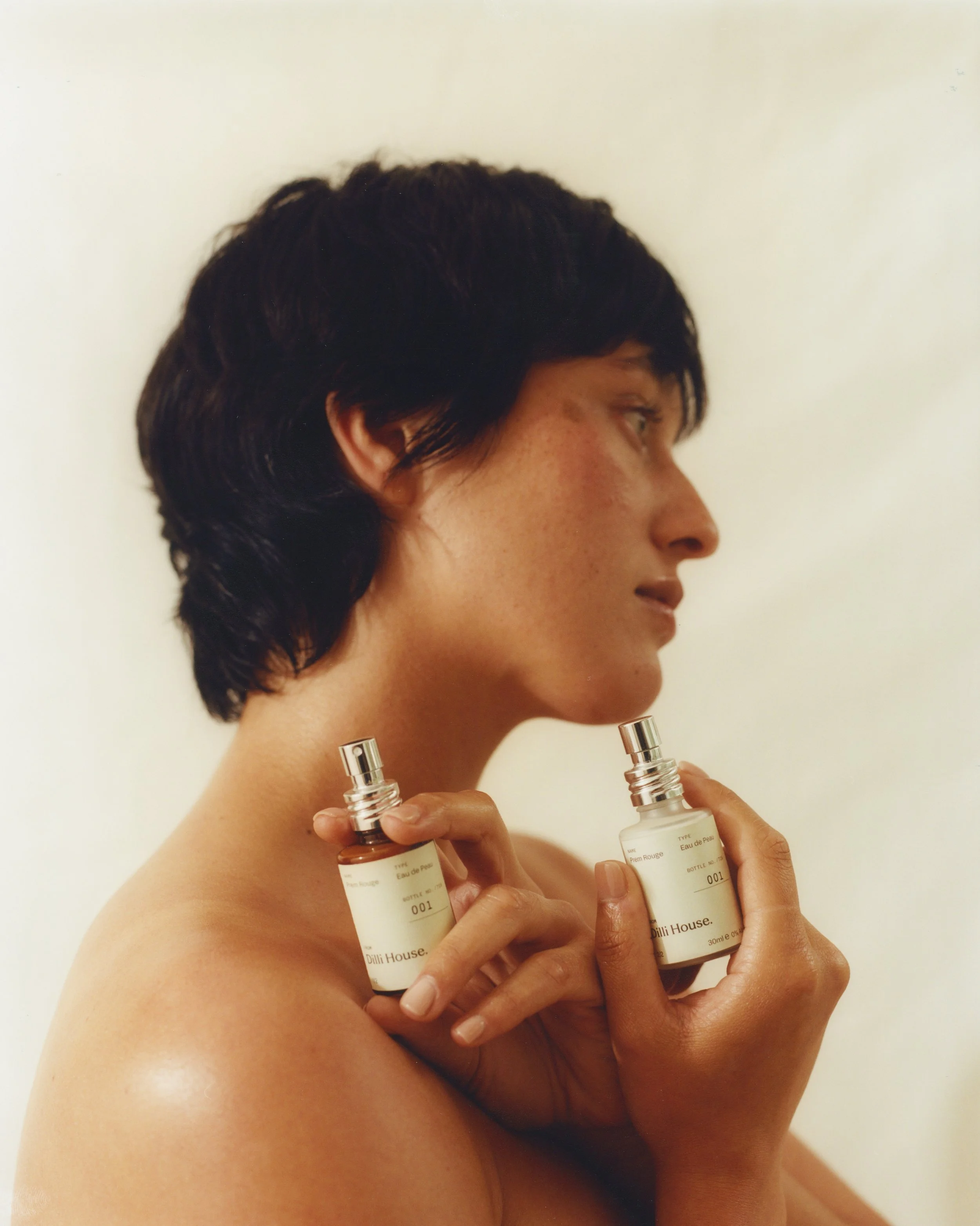 Woman holding Prem Rouge Eau de Peau natural fragrance bottle by Dilli House