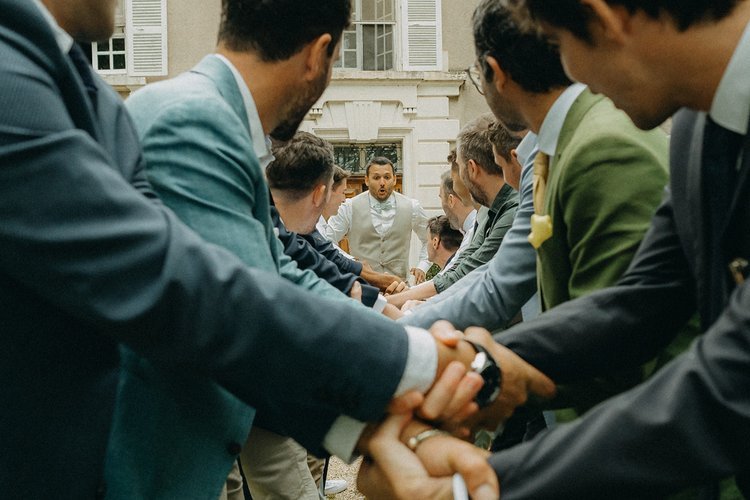 Groupe d'hommes en train de se serrer les mains lors d'un événement formel à l'extérieur.