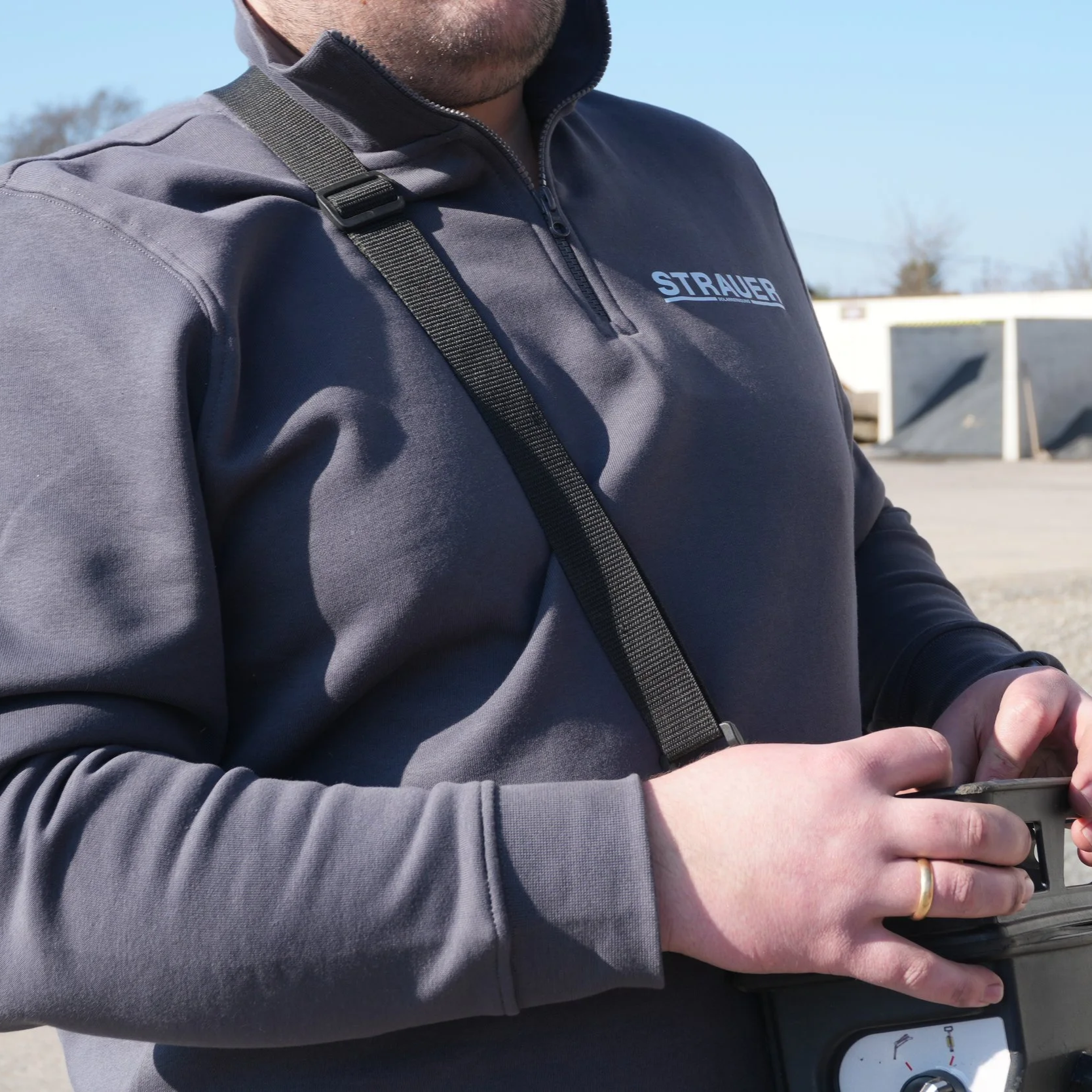 Nahaufnahme einer Fachkraft in STRAUER-Arbeitskleidung, die einen Kettensteiger für den Reinigungseinsatz an der Solaranlage steuert.