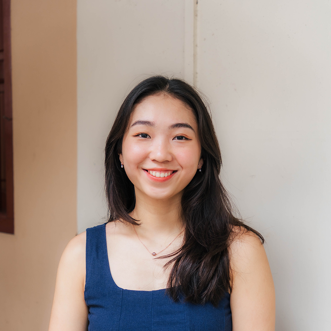 Young woman smiling against a plain background
